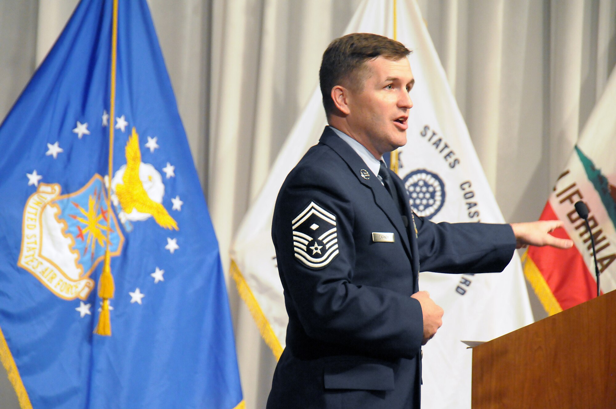 Senior Master Sgt. Jeremy Carney, SMC first sergeant, speaks at Raytheon’s Salute to Veterans, Nov. 6.   Bruce Blackmon, Raytheon Space and Airborne Systems Mission Assurance director and a former Army captain, also spoke. At the event, Blue Star Mothers collected items for care packages to send to deployed troops. (Photo by Joe Juarez)