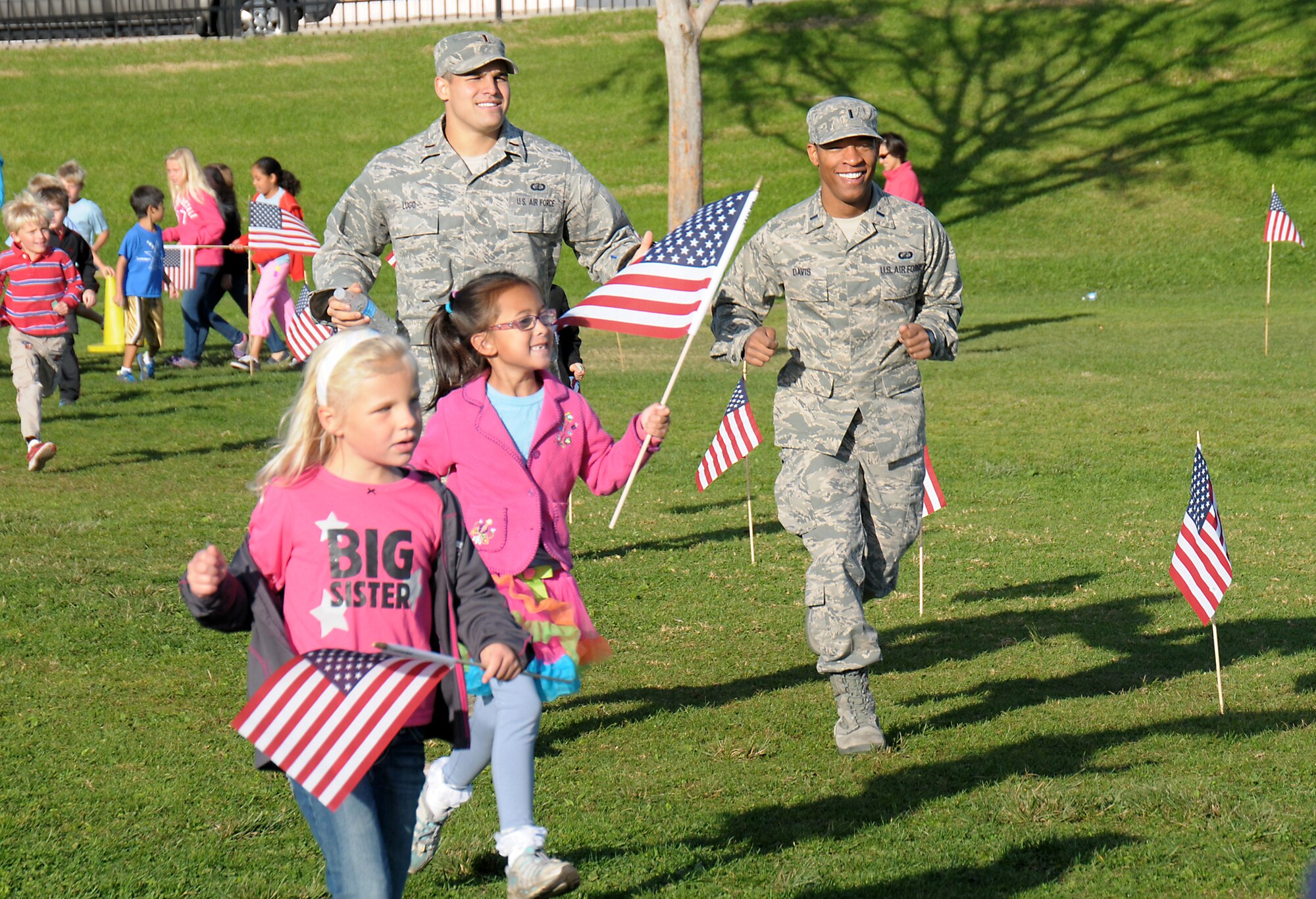 Lieutenant Francisco Lugo and Lt. Berkley Davis run with students from Jefferson Elementary School’s Running Club, Nov. 9.  The students in the club run, skip, hop or walk for 20 minutes every day and earn points which can be used for prizes and other incentives.  (Photo by Joe Juarez)