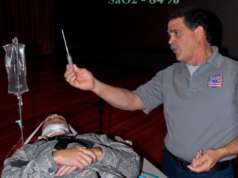Airman 1st Class James Bybee, a member of the 68th Electronics Warfare Squadron, is placed on a spinal board for transportation to a hospital by Ronnie Garcia, a Florida Stay Alive From Education instructor, as part of an automobile accident victim demonstration during the “Street Smart” program at the Holiday Traffic Safety Campaign Nov. 15. (U.S. Air Force photo/Kevin Gaddie) 