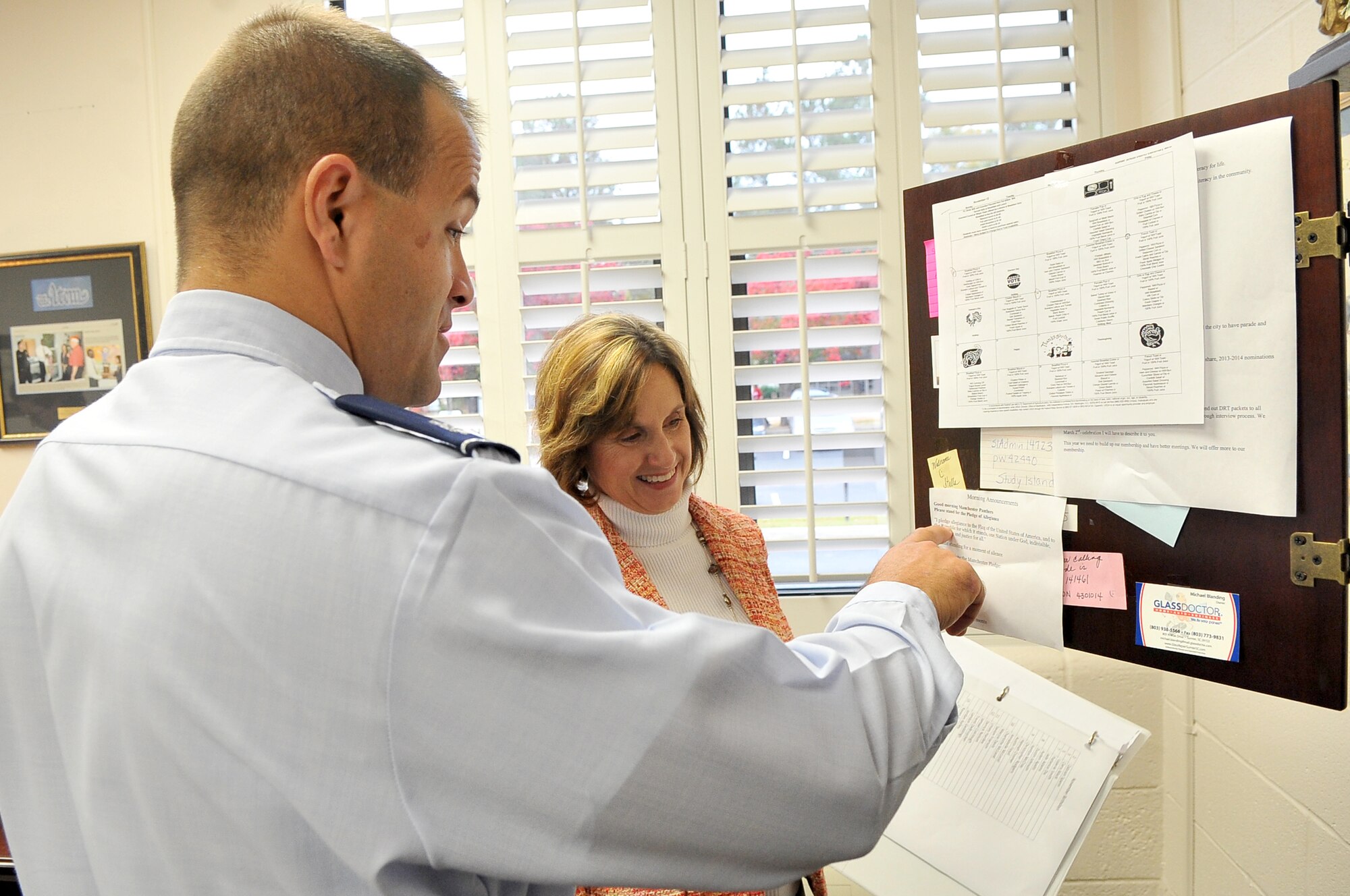 U.S. Air Force Lt. Col. Jeffrey Jarry, 28th Operational Weather Squadron commander, points out the morning announcements with  Dr. Joy Tye, Manchester Elementary School principal, Pinewood, S.C., Nov. 13, 2012. The student population comes mostly from a rural community around Pinewood. (U.S. Air Force photo by Airman 1st Class Ashley L. Gardner/ Released)

