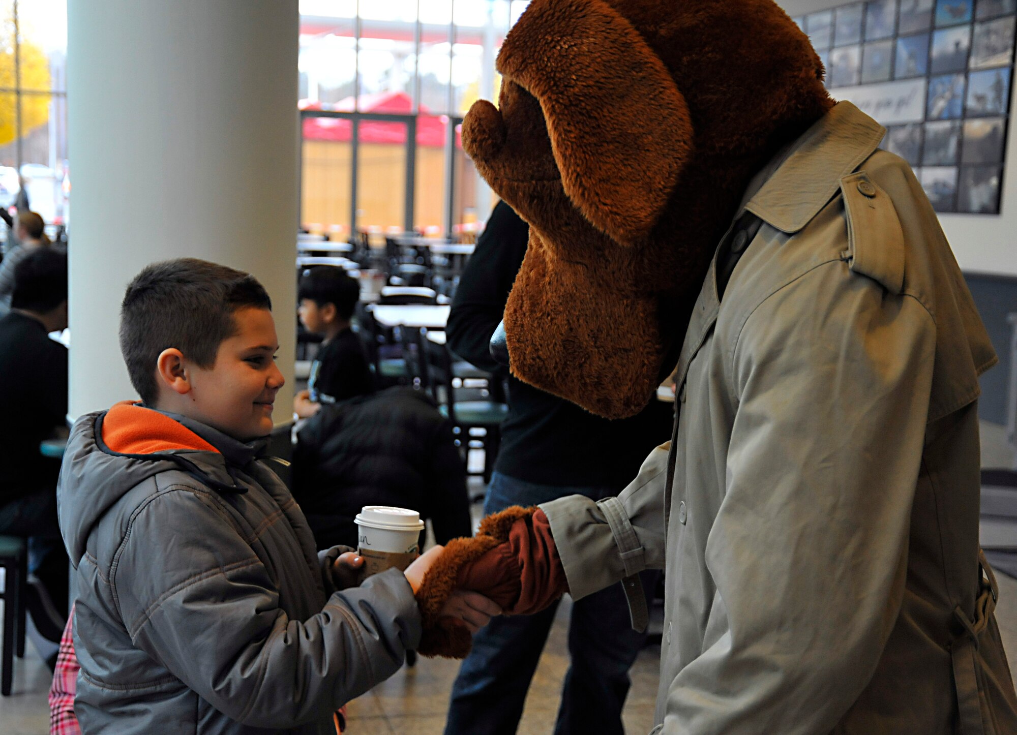 Sean Hogan, 10, son of Master Sgt. Chris Hogan, 86th Security Forces flight chief, shakes hands with the security forces mascot, Scruffy, at a neighborhood watch outreach booth, Ramstein Air Base, Germany, Nov. 16, 2012. The Neighborhood Watch program is just one of many services offered by security forces and the Air Force Office of Special Investigations to ensure the safety of the community. (U.S. Air Force photo/Airman 1st Class Trevor Rhynes)