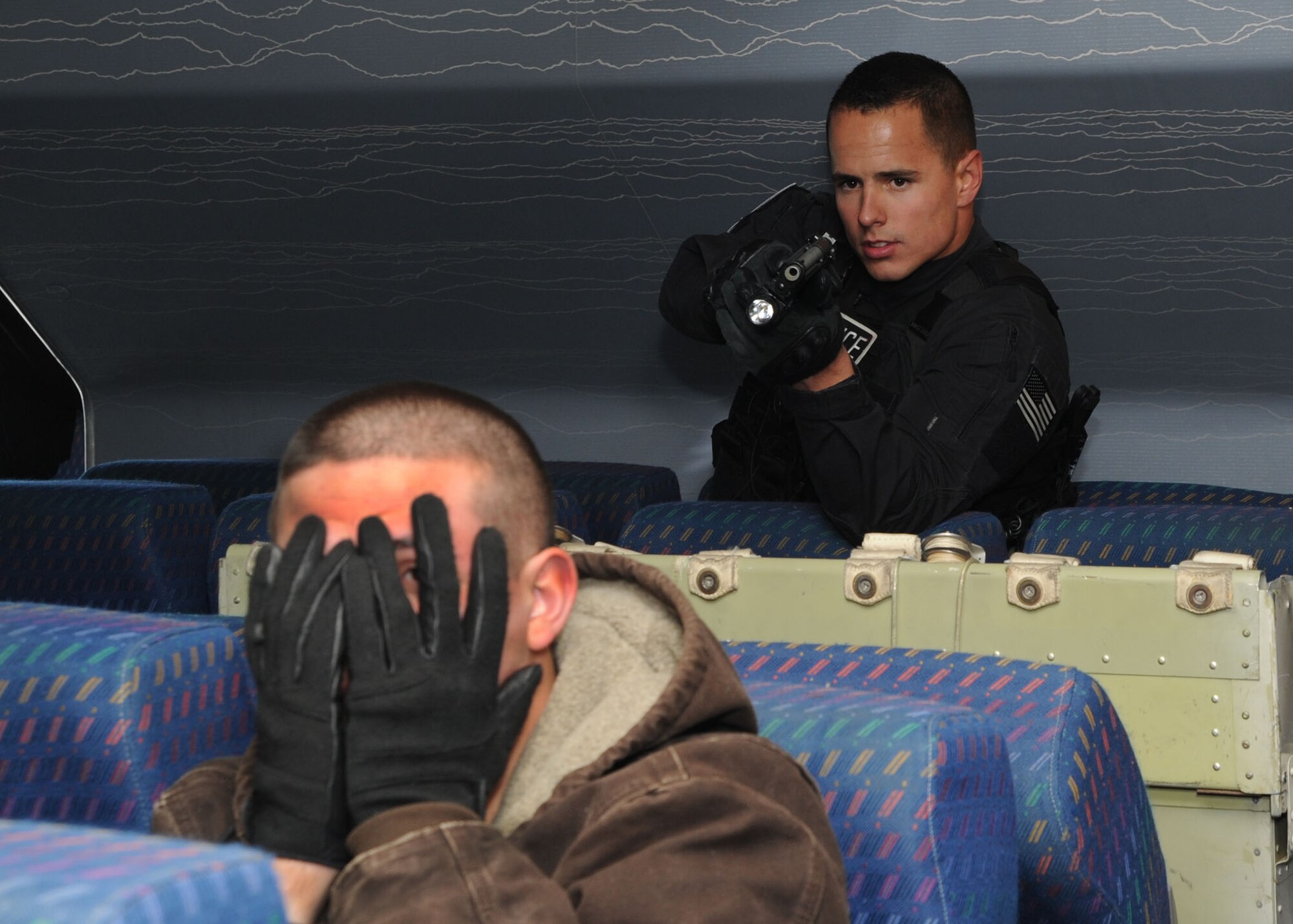 Staff Sgt. Jason Leavens, 811th Security Forces Squadron Raven and Andrews Emergency Services Team member, controls an Airman acting as an opposing force during an anti-hijacking training exercise Nov. 9, 2012, at the Joint Training Facility at Baltimore Washington International Airport, Md. The exercise was a joint effort between the Andrews EST and the Raven team where they practiced tubular assaults during a mock hijacking scenario.   (U.S. Air Force photo/ Senior Airman Bahja J. Jones) 
