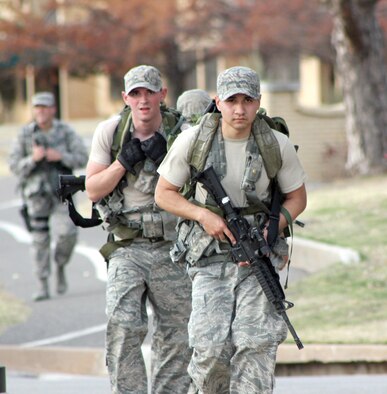 Bearing the weight of 35-pound rucksacks on a 7.5-mile rucksack march, Senior Airmen Robert Mayhew and Jose Armenta, from the 72nd Security Forces Squadron, compete against the clock and five other teams during the Nov. 10 Defender Challenge held here (Air Force photo by Tech. Sgt. Timothy Nesbitt)