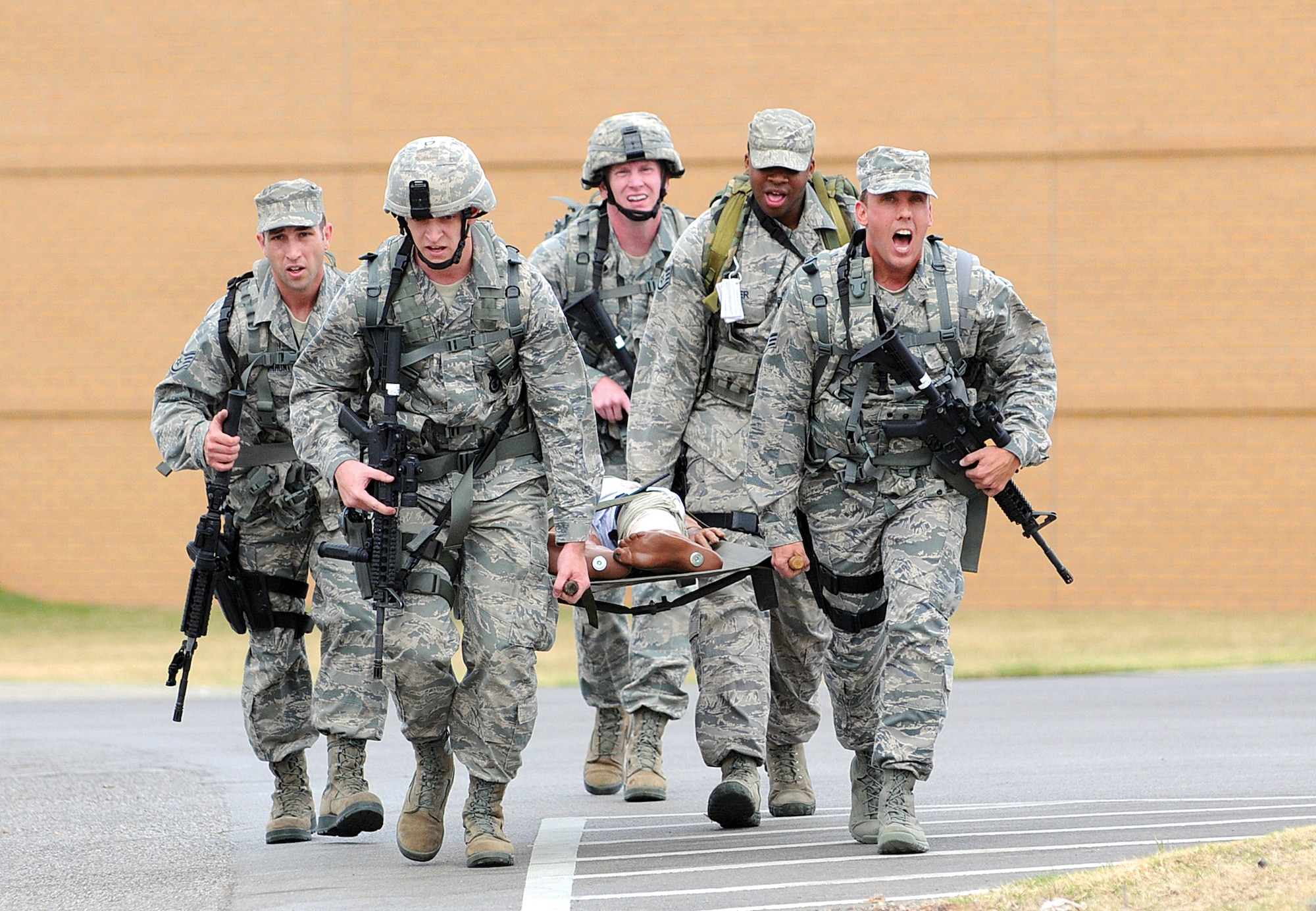 After a half-mile uphill litter carry race in the Self-Aid/Buddy Care challenge, the 507th Air Refueling Wing Security Forces Squadron team wills themselves to the finish line during the Nov. 10 Defender Challenge competition. Six teams from Tinker’s 72nd Security Forces, Altus’ 97th SFS and Tinker’s 507th ARW/SFS were pushed to the limits in various combat skills during the first event of its kind here since the 1980s. .  (Air Force photo by Margo Wright)