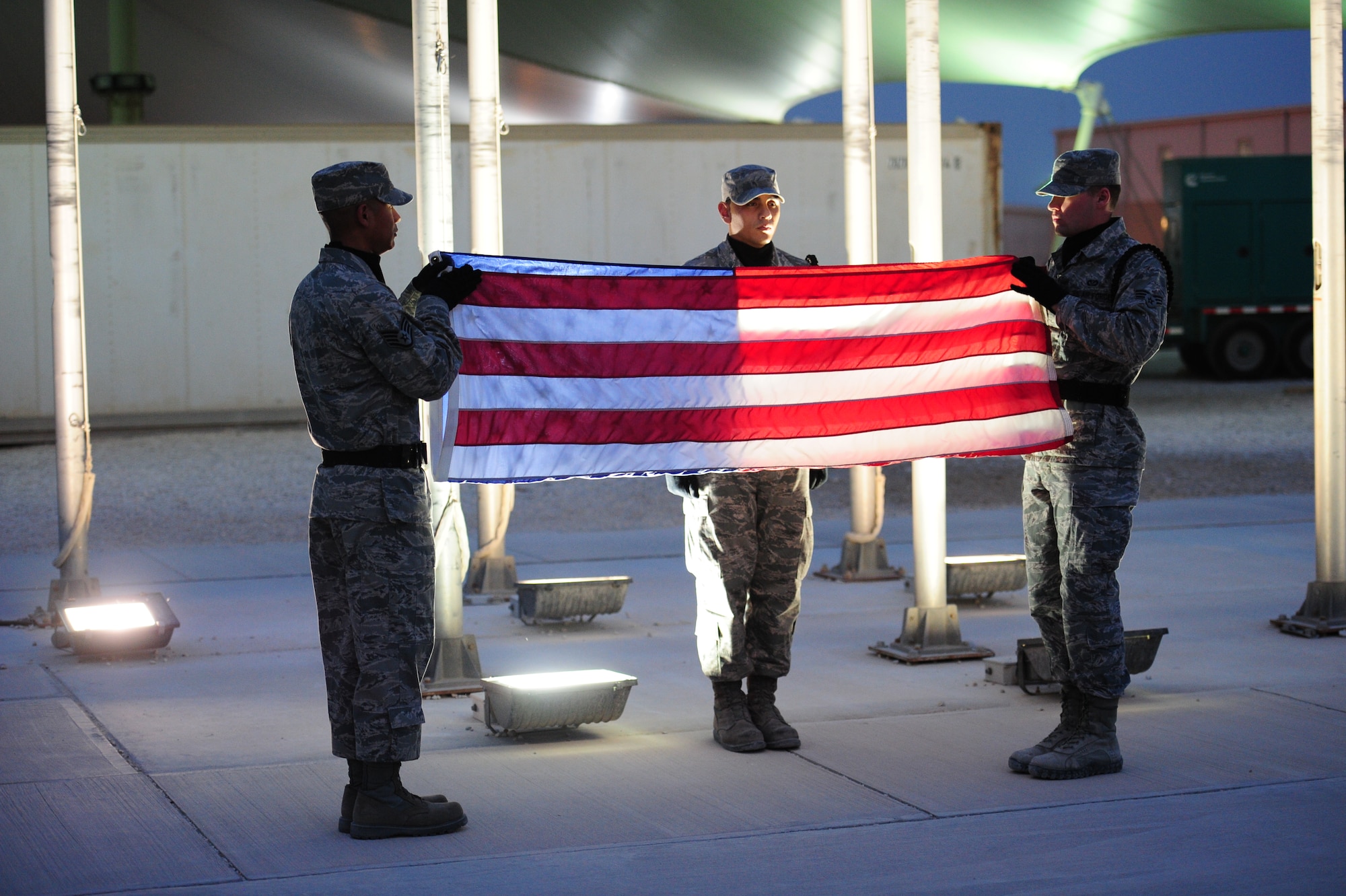 SOUTHWEST ASIA - From left to right, Staff Sgt Fernando Reyes, Airman 1st Class Christian Ramirez and Senior Airman Joseph Royal, members of the 379th Air Expeditionary Wing Honor Guard members, fold the flag during a Veteran’s Day Ceremony Nov. 11, 2012. (U.S. Air Force photo/Master Sgt. Brendan Kavanaugh)