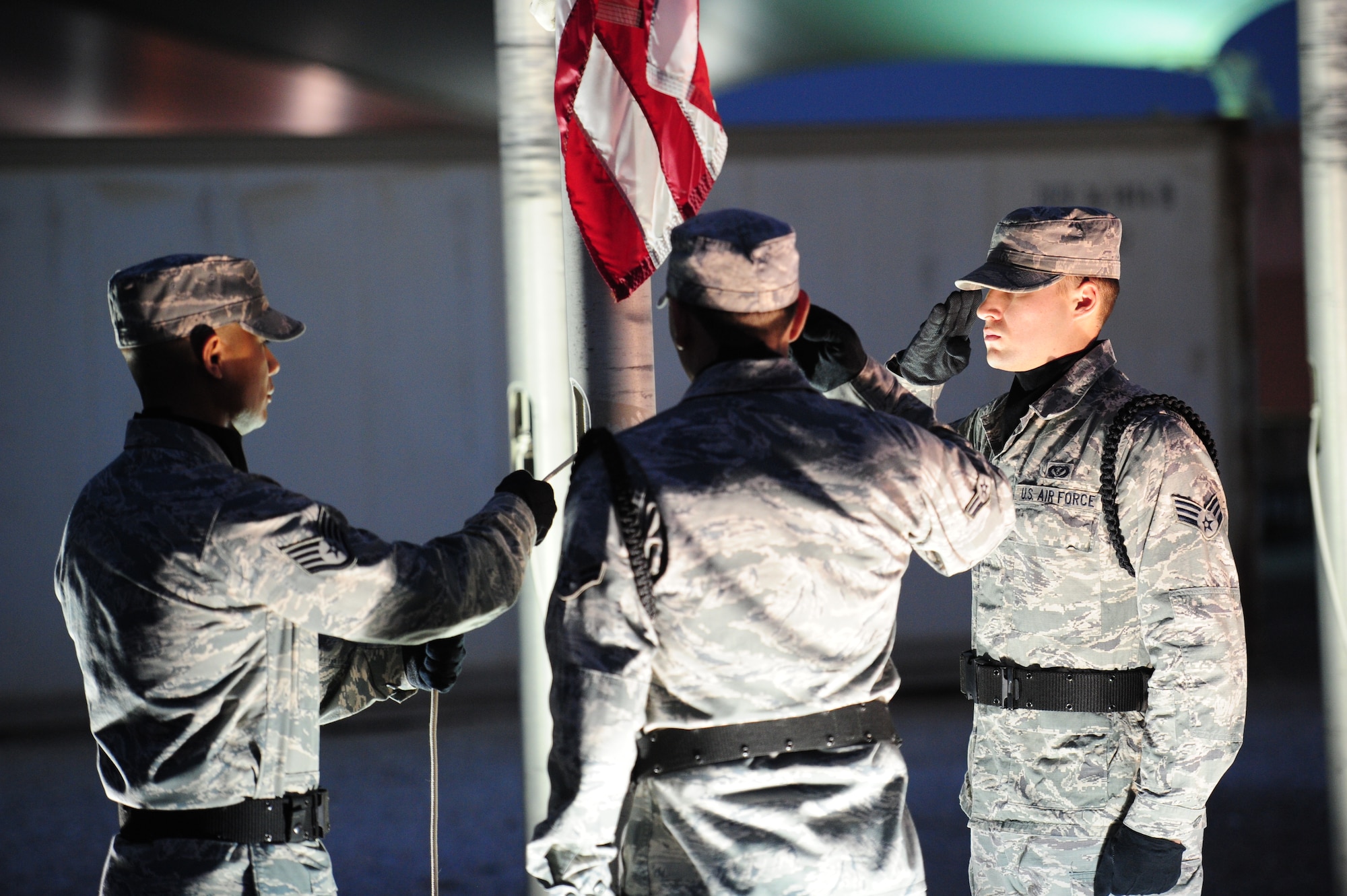 SOUTHWEST ASIA - From left to right, Staff Sgt Fernando Reyes, Airman 1st Class Christian Ramirez and Senior Airman Joseph Royal, members of the 379th Air Expeditionary Wing Honor Guard members, lower the flag during a Veteran’s Day Ceremony Nov. 11, 2012. (U.S. Air Force photo/Master Sgt. Brendan Kavanaugh)