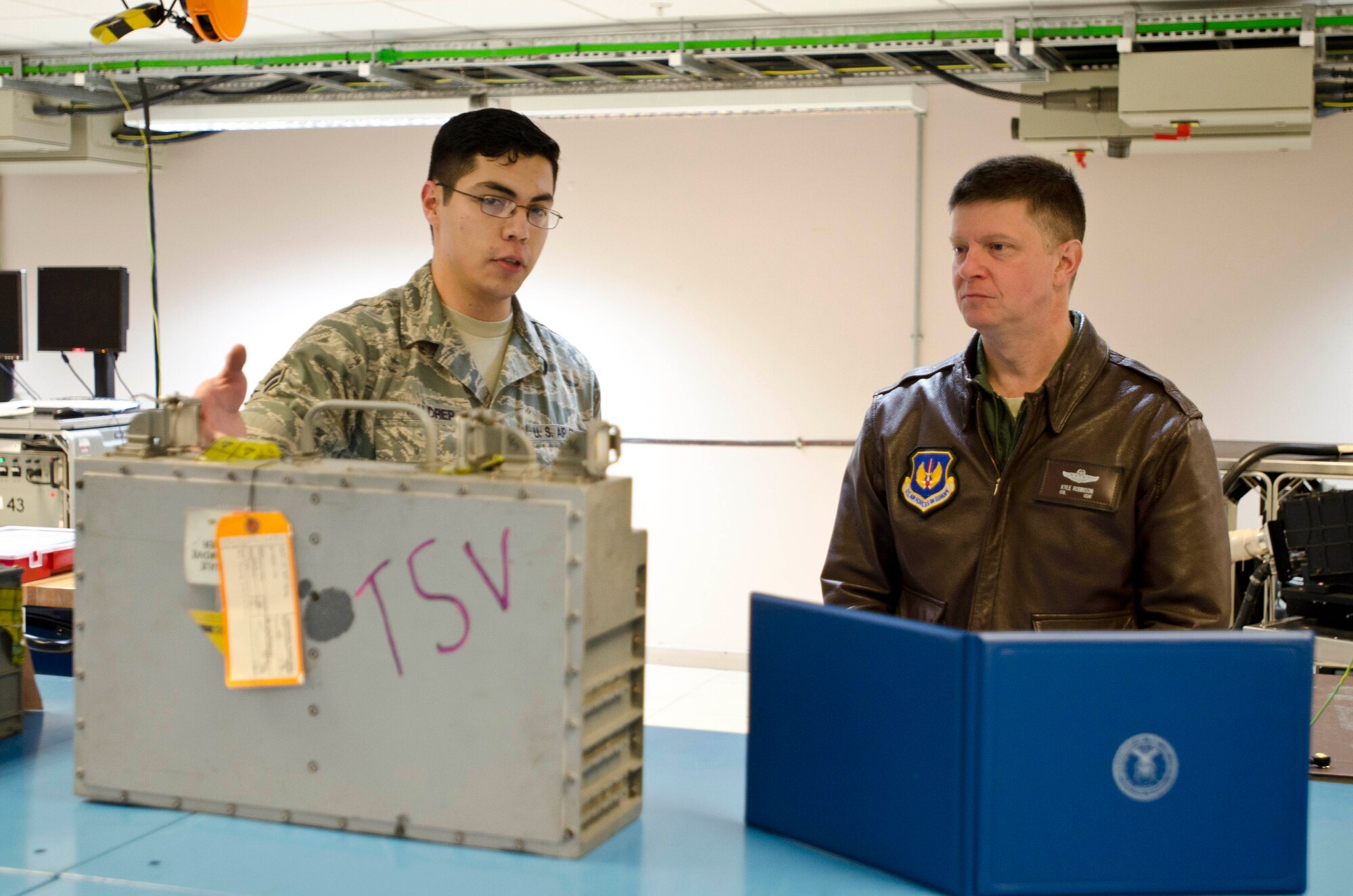 ROYAL AIR FORCE LAKENHEATH, England - Airman 1st Class Travis Waldrep, 48th Component Maintenance Squadron avionics system journeyman and native of Cherokee, Okla., speaks to Col. Kyle Robinson, 48th Fighter Wing commander, about avionics equipment Nov. 15, 2012. The avionics intermediate shop recently achieved 100-percent functionality on all test equipment. Airmen from the intermediate section provide highly effective and efficient intermediate level support to maintain electronics on the F-15. (U.S. Air Force photo by Staff Sgt. Stephen Linch)