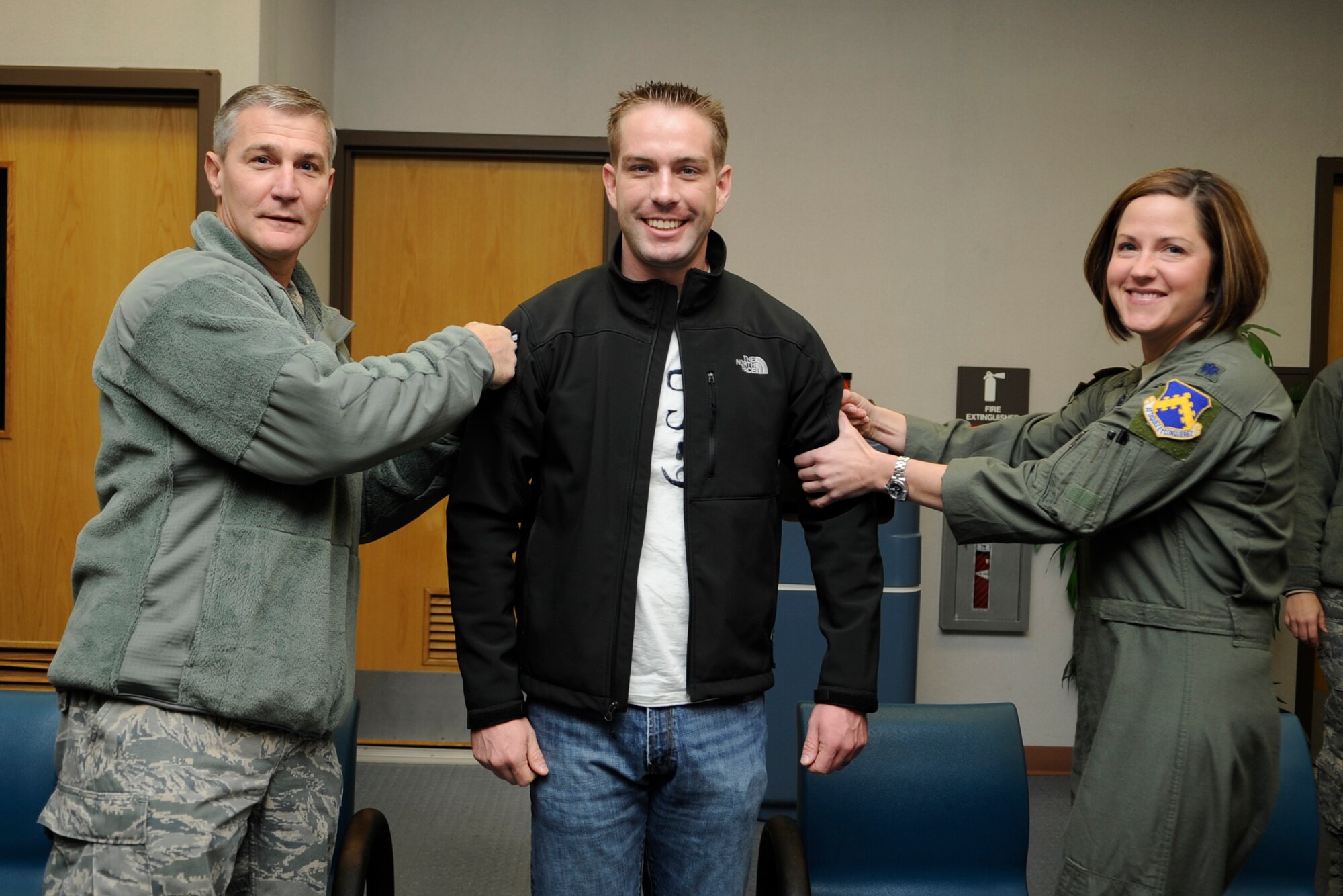 Staff Sgt. Adam Crown, 8th Operations Support Squadron, receives a surprise promotion under the Stripes for Exceptional Performers program from Col. John W. Pearse, 8th Fighter Wing commander, left, and Lt. Col. Samantha Weeks, 8th OSS commander, at Kunsan Air Base, Republic of Korea, Nov. 15, 2012. Crown was selected to be promoted to technical sergeant because of his outstanding performance during his time at the Wolf Pack. He received notification while waiting for his military airlift to his next duty station. (U.S. Air Force photo/Senior Airman Brigitte N. Brantley)