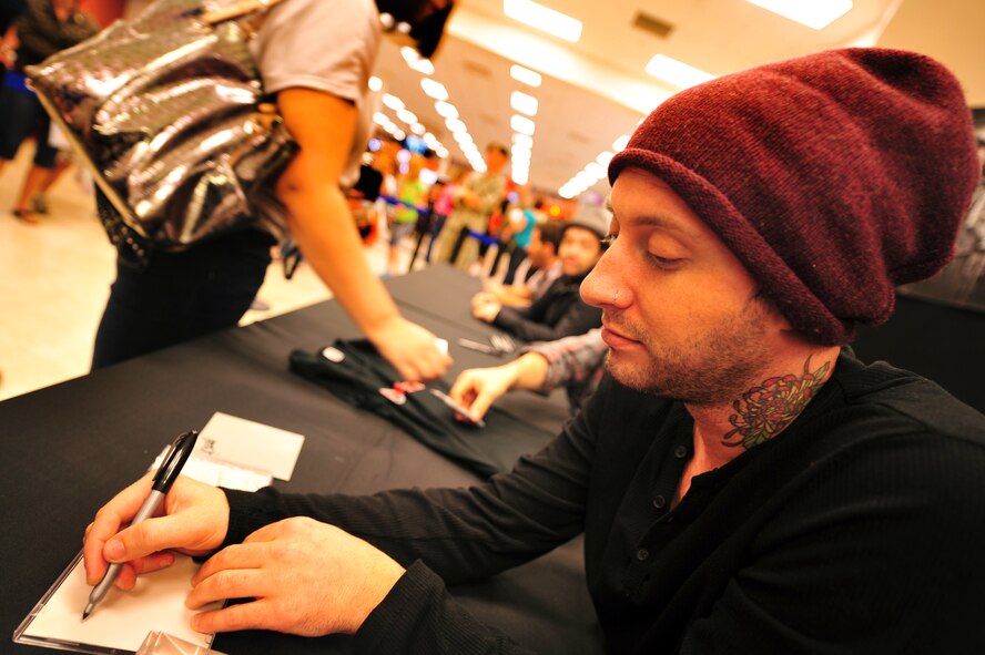Jesse Charland, bass player for Hoobastank, an American rock band, signs an autograph for a fan at the Kadena Base Exchange on Kadena Air Base, Japan, Nov. 14, 2012. Hundreds of service members and their families came out to the BX to meet members of Hoobastank before they performed a free concert put on by the 18th Force Support Squadron at to the Emery Bowling Center Nov. 15. (U.S. Air Force photo/Staff Sgt. Sara Csurilla)