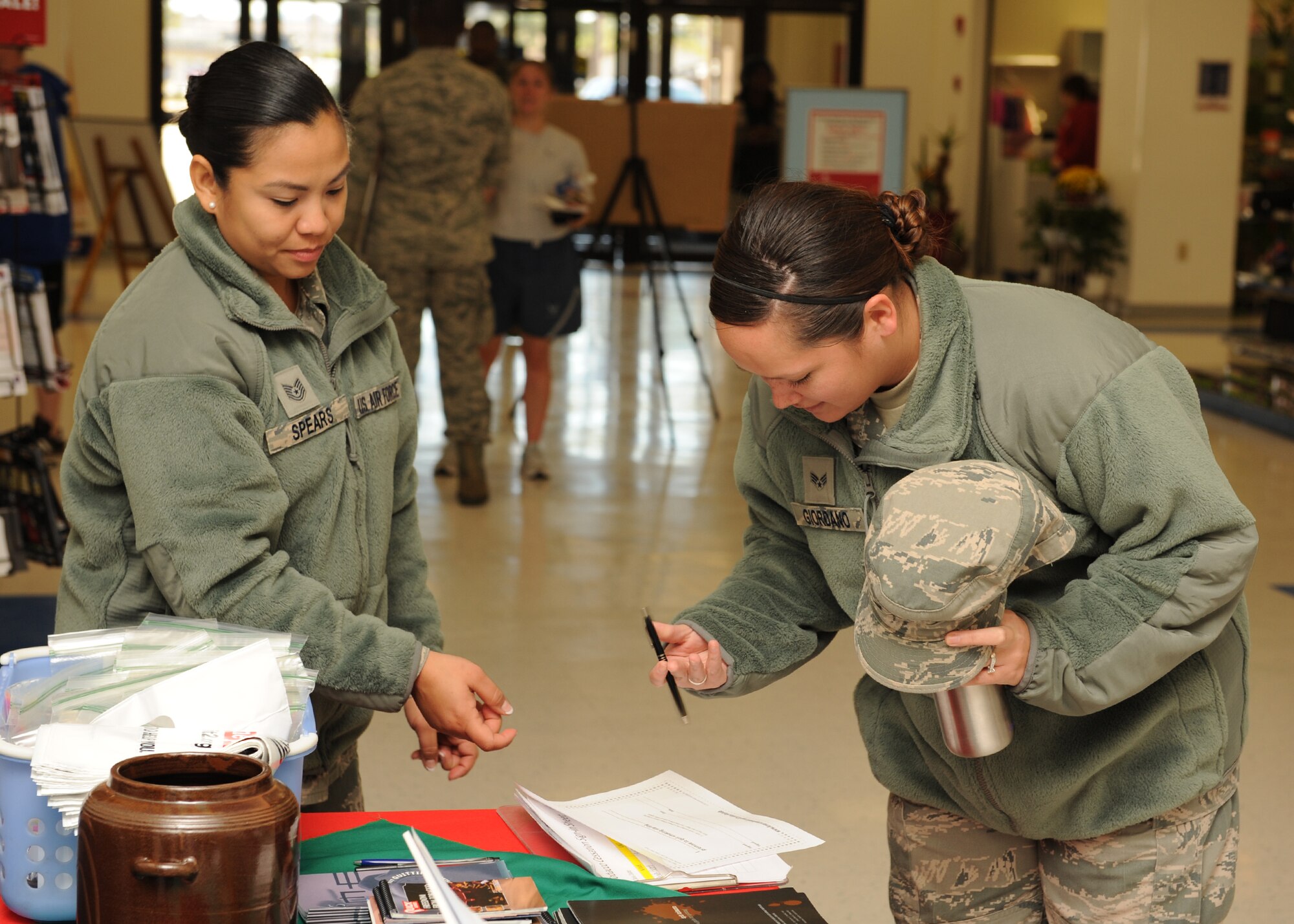 Tech. Sgt. Celeste Spears, 8th Medical Operations Squadron, assists Senior Airman Denise Ciordano, 8th Civil Engineer Squadron, in signing a pledge to quit smoking for a day during the Great American SmokeOut event on Kunsan Air Base, Republic of Korea, Nov. 15, 2012. The event is an effort to a smoke free Air Force and to help those who smoke, quit. (U.S. Air Force photo/Staff Sgt. Jonathan Fowler)
