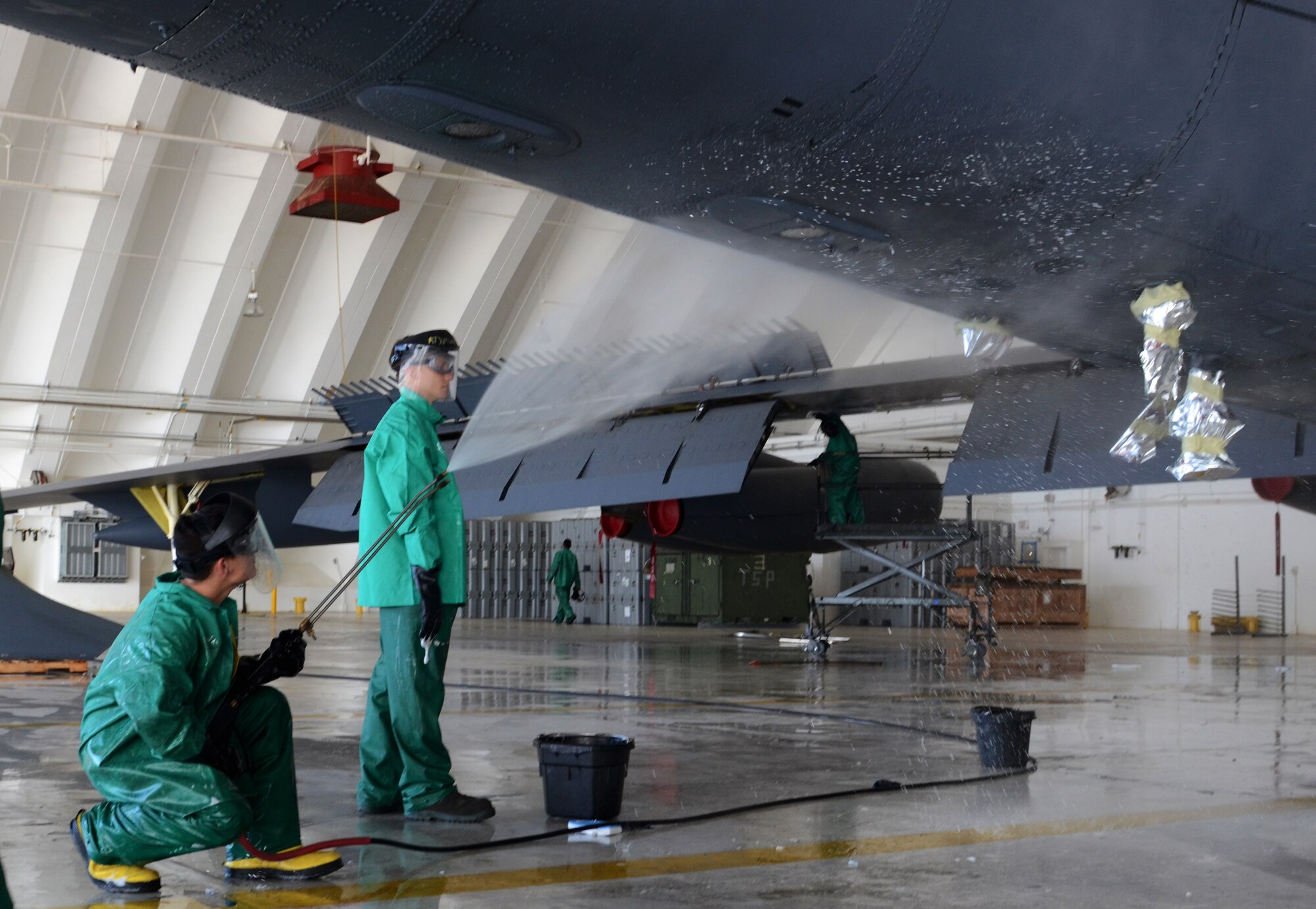ANDERSEN AIR FORCE BASE, Guam— Airman 1st Class Christopher Rider (left) and Senior Airman Matthew Fernandez, 96th Expeditionary Aircraft Maintenance Unit weapons load technicians, finish spraying the bottom of a B-52 Stratofortress here, Nov. 15. Due to the corrosive environment on Guam, each B-52 is cleaned and lubricated every 30 days instead of the required 120 days.  (U.S. Air Force photo by Senior Airman Benjamin Wiseman/Released)