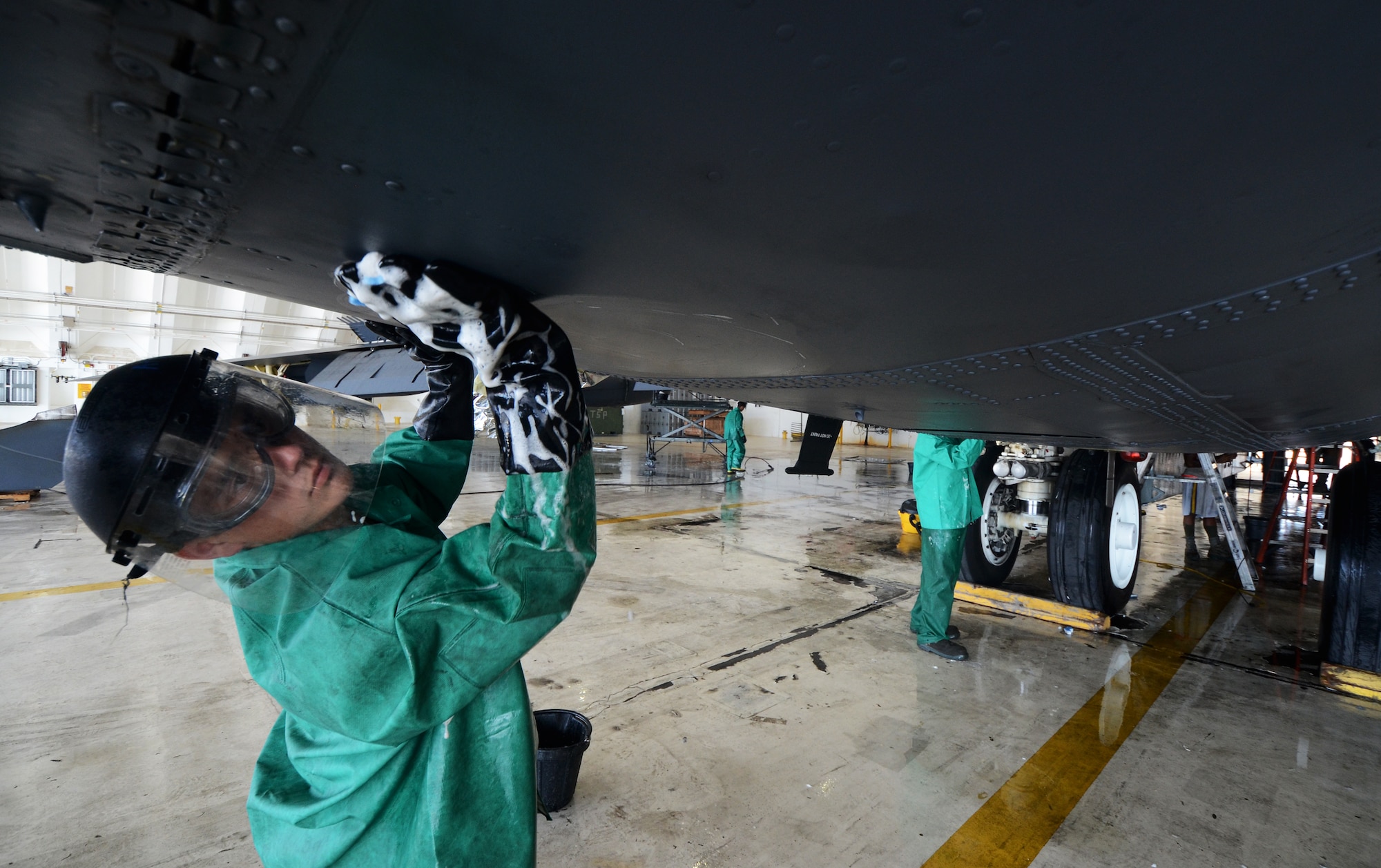 ANDERSEN AIR FORCE BASE, Guam— Airman 1st Class Christopher Rider, 96th Expeditionary Aircraft Maintenance Unit weapons load technician, scrubs the underbelly of a B-52 Stratofortress here, Nov. 15.  Members from the EAMXU take monthly rotations on wash-rack duty. (U.S. Air Force photo by Senior Airman Benjamin Wiseman/Released)