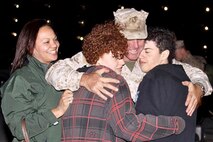 A Marine Corps Systems Command Marine returning from deployment is welcomed home by his family. The Command's Family Readiness On Point Team works hard to keep faith with families by communicating, connecting and caring