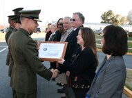 At Marine Corps Systems Command’s (MCSC) 25th anniversary commemoration, Brigadier General Frank Kelley, MCSC Commander, presents Robyn Fait, Operations Manager for Marine Air-Ground Task Force Command, Control and Communications, with a certificate for continuously working for the Command since its establishment in November 1987.