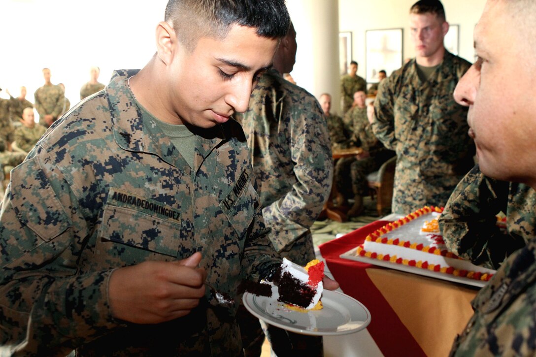 Lance Cpl. Francisco Andrade-Dominguez, a supply administration and operations clerk with the communications detachment, 31st Marine Expeditionary Unit, and a native of Denver, Colo., takes a bite of cake as the youngest Marine present in the unit’s cake cutting ceremony for the 237th Marine Corps birthday here, Nov. 16. The cake was passed to him by the oldest Marine present, Sgt. Maj. Gonzalo Vasquez, the 31st MEU Sergeant Major and a native of Belize, Central America. The 31st MEU is the Marine Corps’ force in readiness for the Asia-Pacific region and the only continuously forward deployed MEU.