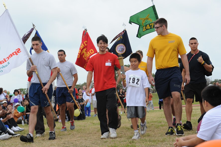 Tatsuyuki Higa, a Kadena Special Olympics athlete, marches a torch down the field on Kadena Air Base, Japan, Nov. 17, 2012. KSO was established in 2000 by the 18th Wing commander as an avenue to build relations with neighboring communities, while providing a meaningful activity for the special needs children and adults. (U.S. Air Force photo/Airman 1st Class Malia Jenkins)  