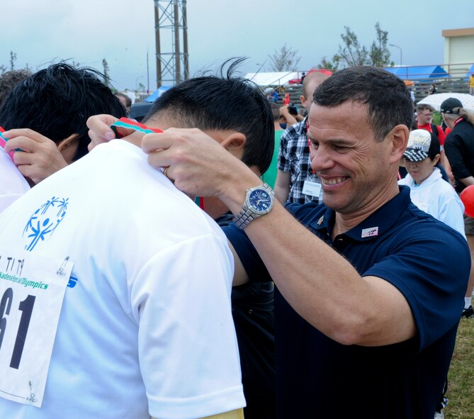 U.S. Air Force Brig. Gen. Matt Molloy, 18th Wing commander, gives a second place medal to a special-needs athlete during the beginning of the 13th annual Kadena Special Olympics on Kadena Air Base, Japan, Nov. 17, 2012. Kadena Special Olympics began in 2000 with about 400 athletes and 600 volunteers as an 18th Wing community goodwill initiative to strengthen U.S. - Okinawa relationships. After 13 years, the event has more than tripled in size and participation.(U.S. Air Force photo/Airman 1st Class Justin Veazie)