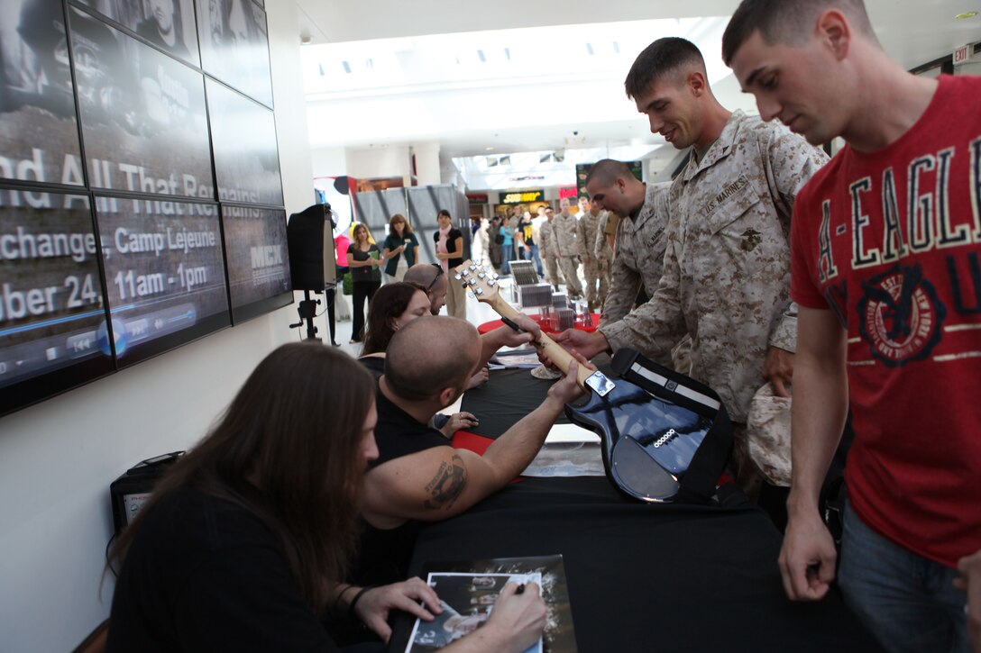 A member of heavy metal band All That Remains signs a guitar for a military fan while visiting service members aboard Marine Corps Base Camp Lejeune recently. The band recently released an album that sold more than 25,000 copies in its first week.   