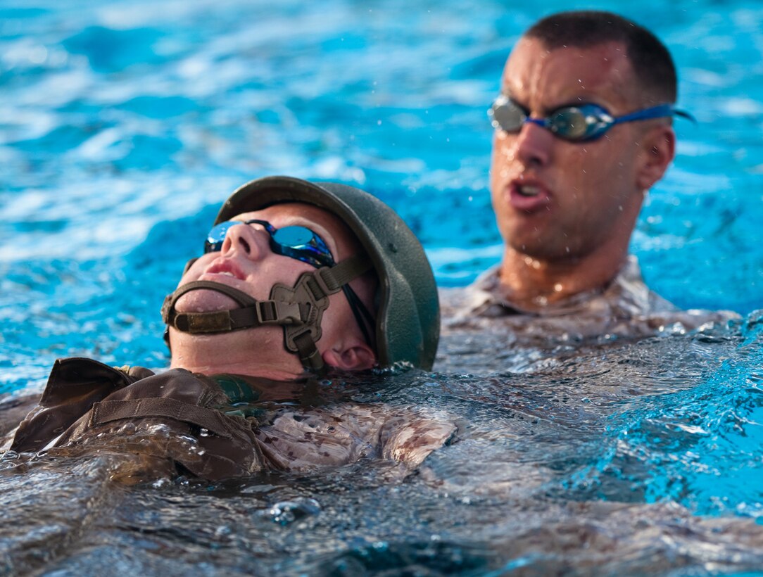 First Lt. Clark Petersen (right), a field artillery officer with 1st Battalion, 12th Marine Regiment, tows a drowning victim to safety during a gear rescue evolution of a Marine Corps Instructor of Water Survival course at the base pool on Marine Corps Base Hawaii, Monday.