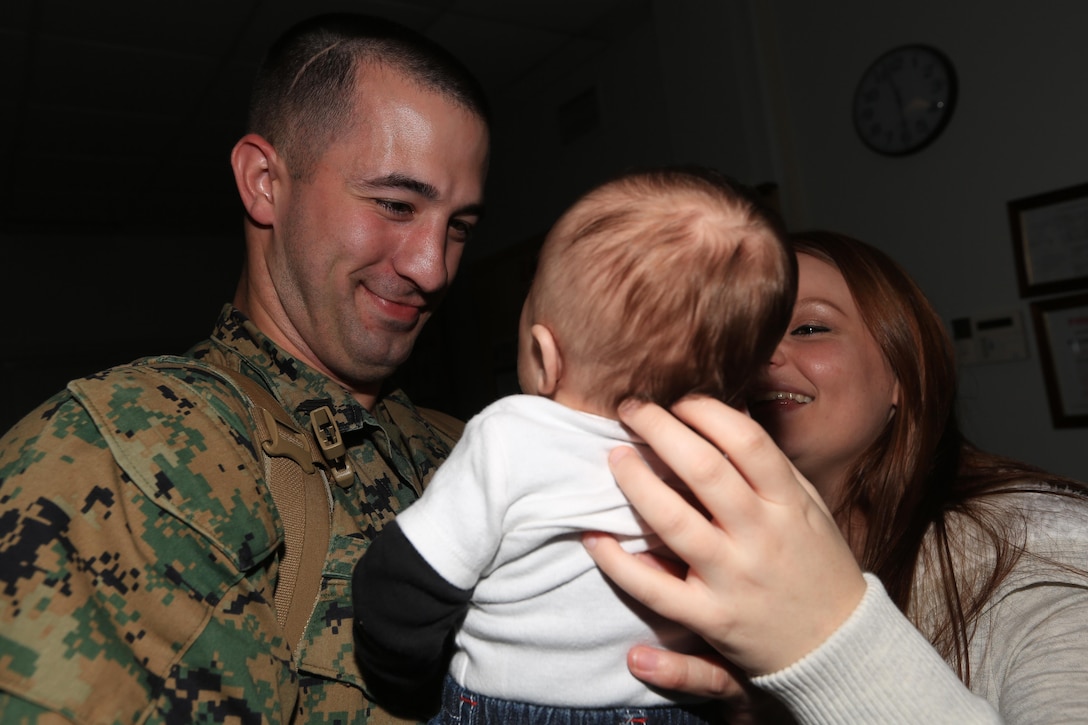 Sgt. Jonathan Selby, a Richmond, Va., native and technical controller with the Joint Task Force Enabler, or JTFE, section of the 24th Marine Expeditionary Unit, embraces his 2-month-old son for the first time alongside his wife inside the 24th MEUs headquarters building on Marine Corps Base Camp Lejeune Nov. 13, 2012, after returning from an eight-month deployment. The JTFE was responsible for the coordination of communications assets throughout the entire 24th MEU, both on land and at sea and were deployed at Naval Air Station Sigonella, Italy.