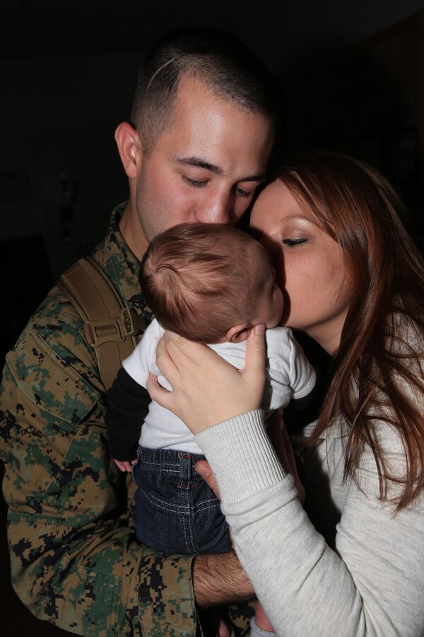 Sgt. Jonathan Selby, a Richmond, Va., native and technical controller with the Joint Task Force Enabler, or JTFE, section of the 24th Marine Expeditionary Unit, embraces his 2-month-old son for the first time alongside his wife inside the 24th MEUs headquarters building on Marine Corps Base Camp Lejeune Nov. 13, 2012, after returning from an eight-month deployment. The JTFE was responsible for the coordination of communications assets throughout the entire 24th MEU, both on land and at sea and were deployed at Naval Air Station Sigonella, Italy.