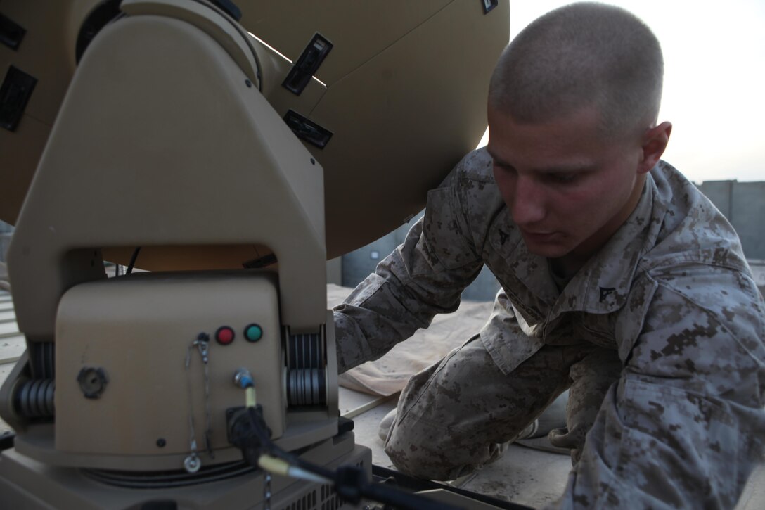 Lance Cpl. Nicholas Patterson, data network specialist and information assurance noncommissioned officer in charge for Regimental Combat Team 7, inspects the Cheetah satellite system used for Internet and communication capabilities for RCT-7.