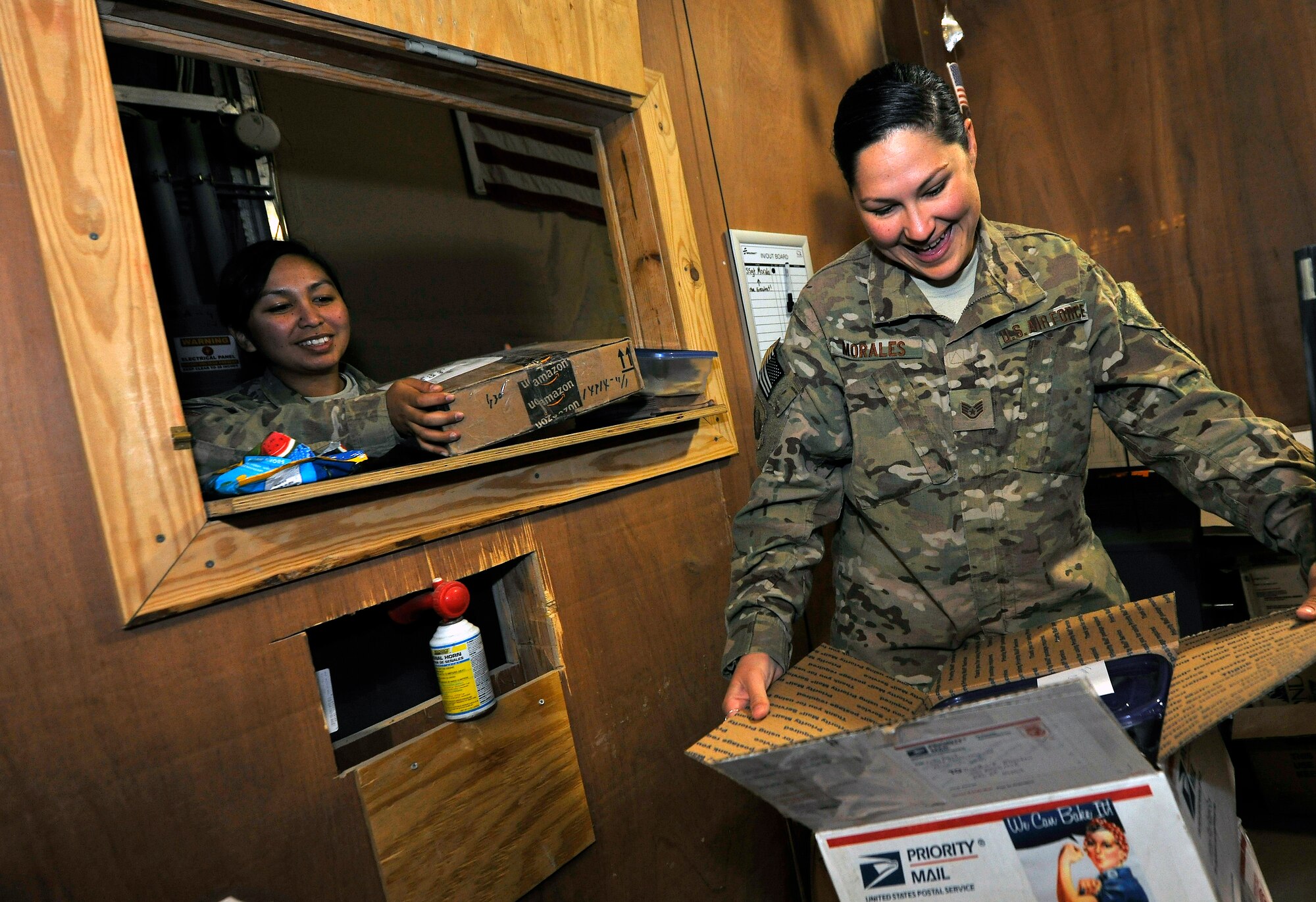 Senior Airman Sasha Brown, a member of the 455th Expeditionary Knowledge Operations Management office, delivers mail to Staff Sgt. Cynthia Morales, 455th Expeditionary Mission Support Group commander’s executive administrator, at Bagram Airfield, Afghanistan, Nov. 19, 2012.  The KOM Office handles the sorting and delivery of the base mail, as well as other functions like managing the Automated Military Postal System with accountable mail notifications. (U.S. Air Force photo/Senior Airman Chris Willis)