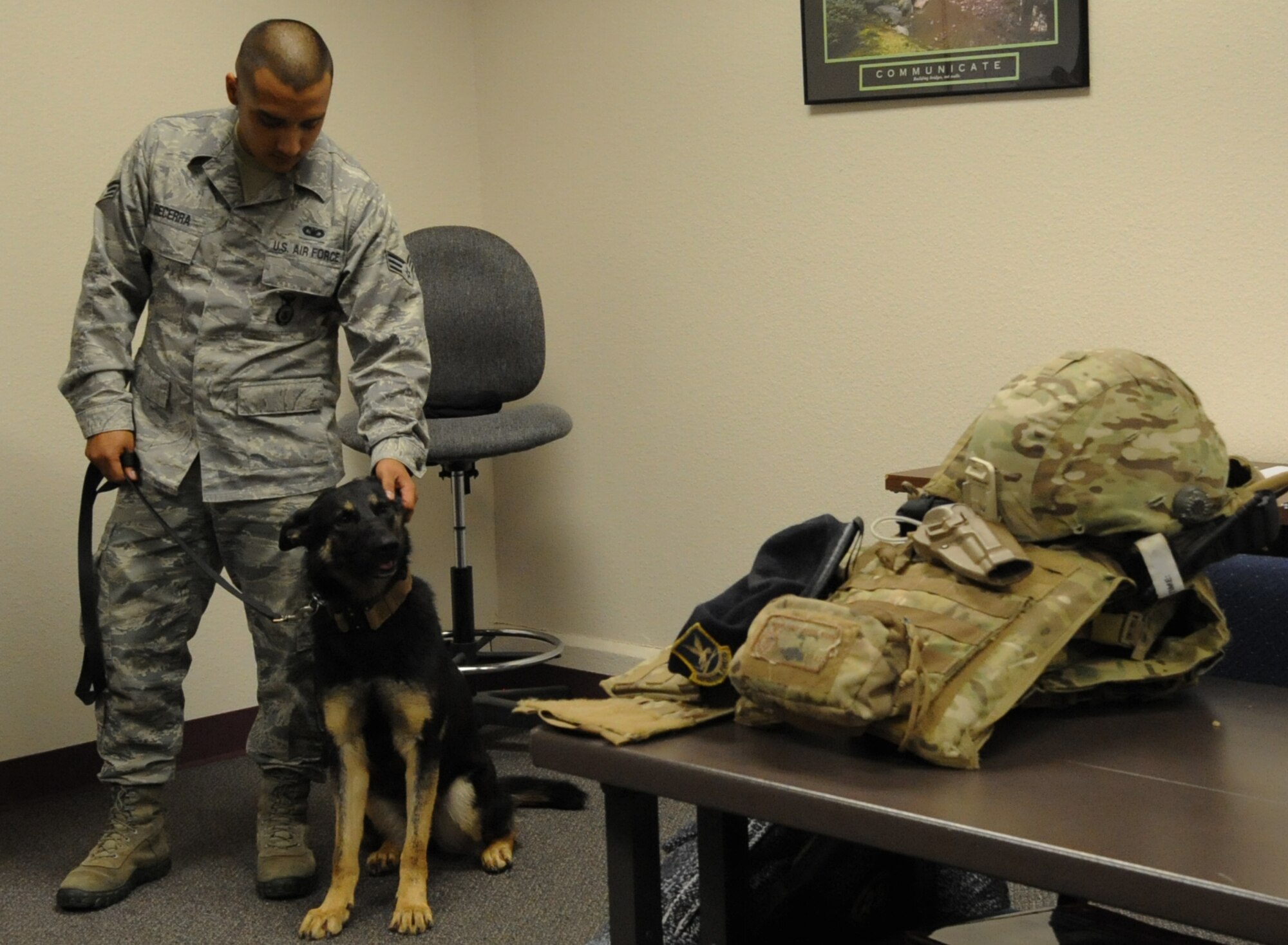 Senior Airman Julian Becerra stands with Molly, a military working dog, during a book signing at the Airman & Family Readiness Center on Nov. 19. Molly will soon be adopted by Staff Sgt. Christopher Hann, a military working dog handler in the 82d Security Forces Squadron. (U.S. Air Force Photo/Kimberly Parker) 