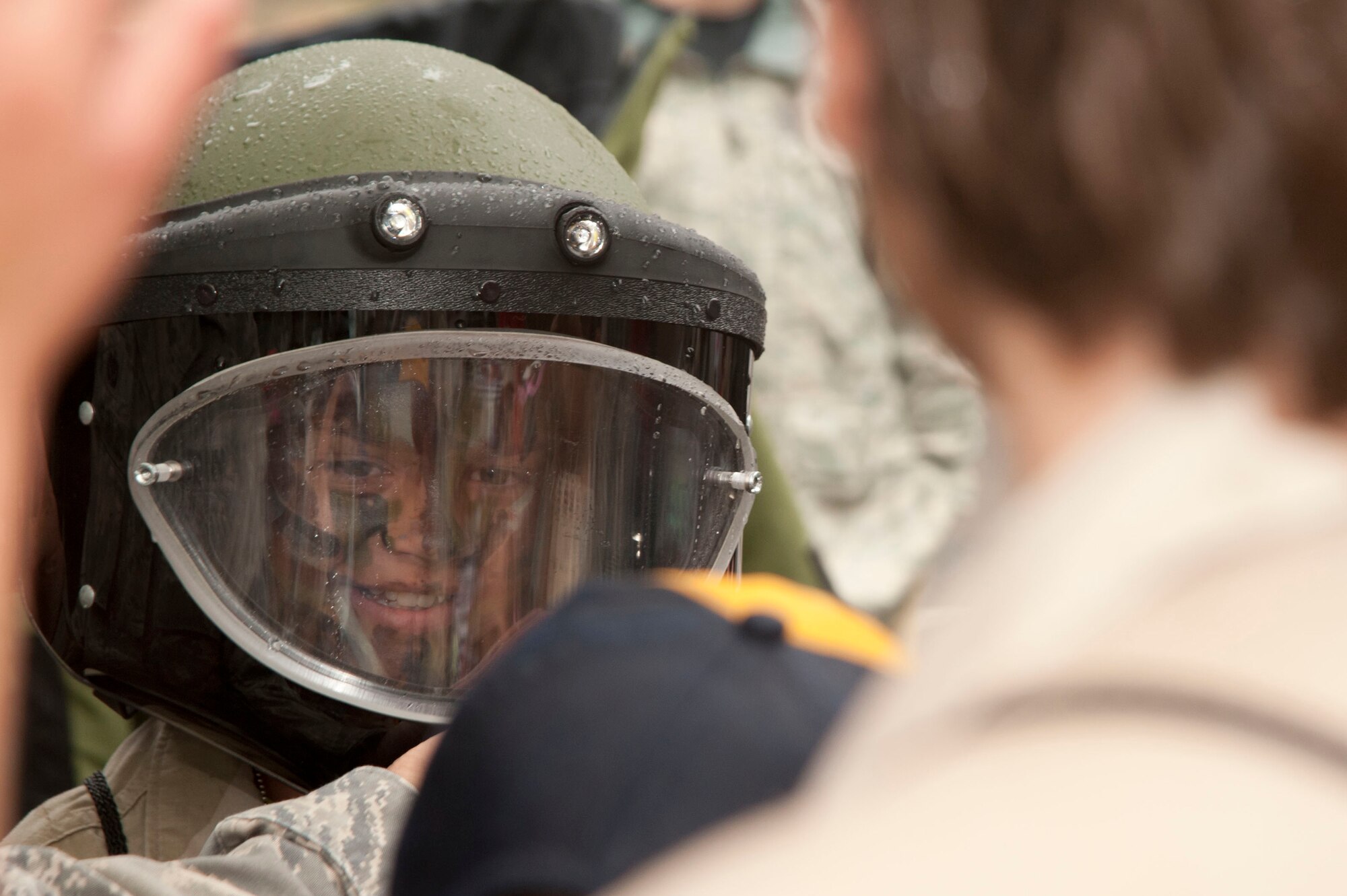 VANDENBERG AIR FORCE BASE, Calif. – Amaya Favreau, Tech. Sgt. Timothy Favreau, a 1st Air and Space Test Squadron flight chief, demonstrates wearing an Explosive Ordinance Disposal helmet during her “deployment” at Cocheo Park during the Kids Understanding Deployments Operations event here Saturday, Nov. 17, 2012. KUDOS simulated a deployment processing line for dependents to help them understand the deployment process their parents or guardians go through before deployment. (U.S. Air Force photo/Senior Airman Lael Huss)