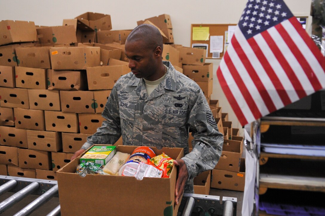 DENVER – Tech. Sgt. Tyrone Clark, 2nd Space Warning Squadron mission crew chief, hands over a finished box so it can be loaded onto a pallet Nov. 19, 2012 at the Food Bank of the Rockies. “We’re a part of the community even if we’re on the air force base,” Clark said. “We have to give back and what better way to give than during the holidays by (preparing) food to those who need it.” (U.S. Air Force photo by Senior Airman Christopher Gross)