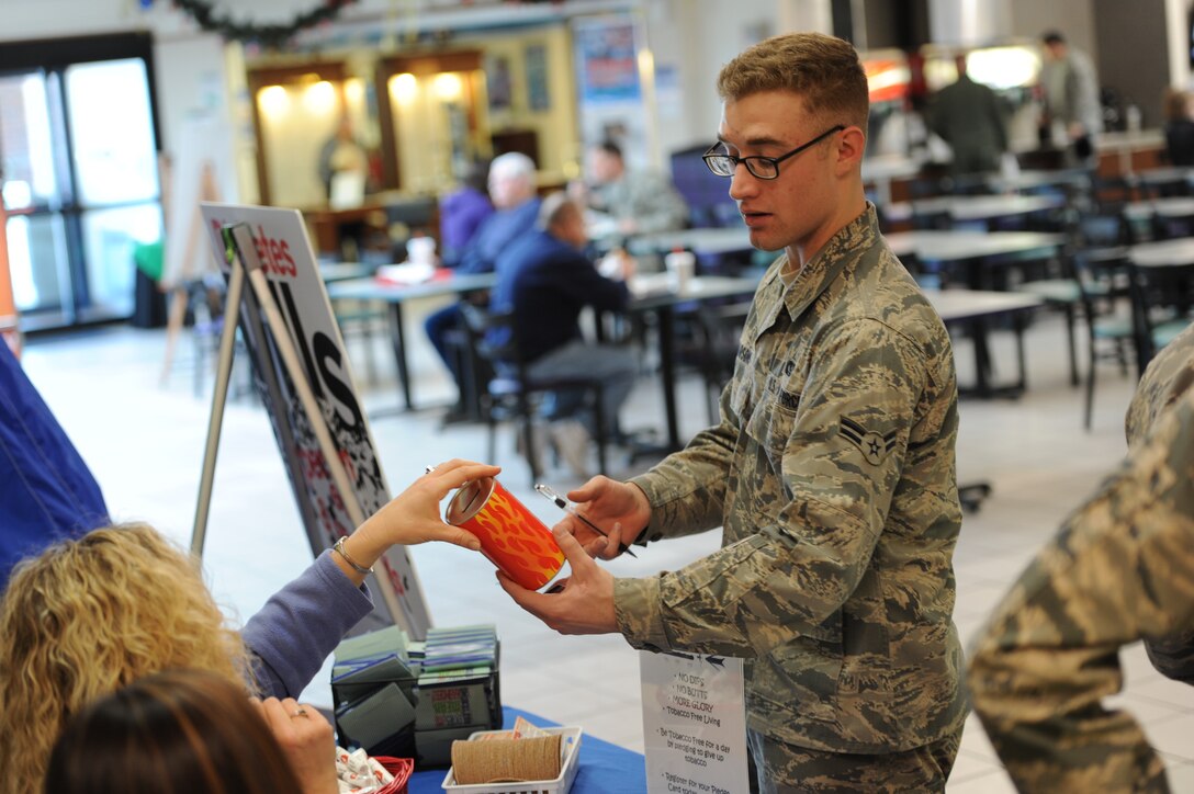 Airman 1st Class Justin Parsons, 28th Civil Engineer Squadron heating, ventilation and air conditioning systems technician, writes his pledge to give up tobacco for one day at a Great American Smokeout information display in the base Exchange at Ellsworth Air Force Base, S.D., Nov. 15, 2012. Those who stopped by the booth learned more about tobacco cessation programs offered by the Health and Wellness Center, signed up to participate in the Cold Turkey Combat Challenge in the Pride Hangar Nov. 16, and committed to stop using tobacco products for at least one day. (U.S. Air Force photo by Airman 1st Class Hrair H. Palyan/Released)