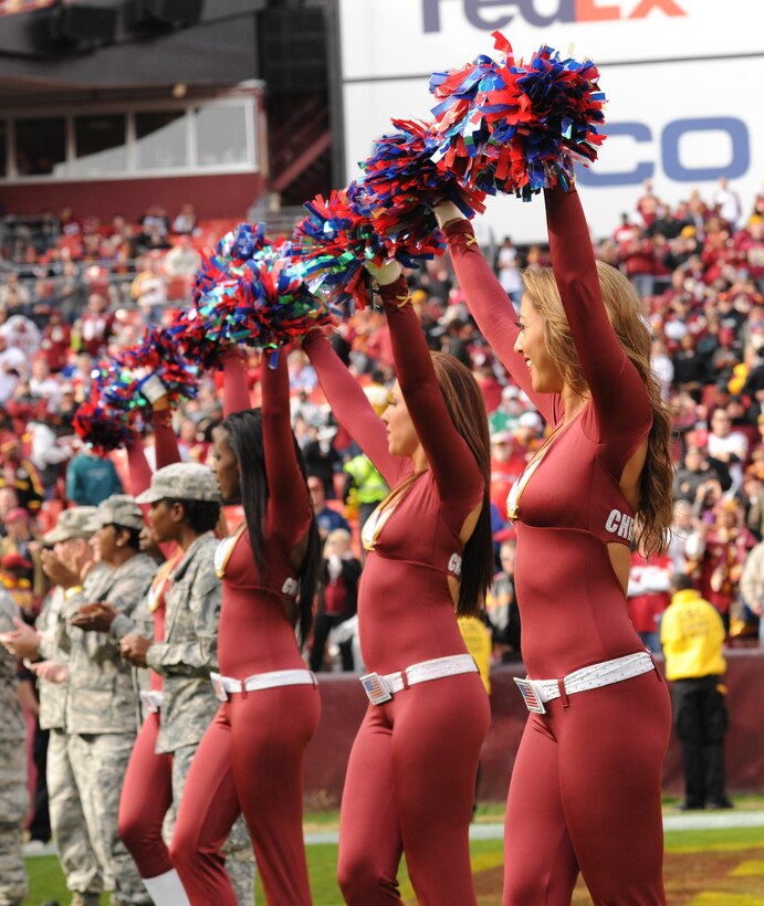 Service members along with Washington Redskins Cheerleaders cheer for Redskins players as they enter the field prior to the military appreciation game at FedEx Field in Landover, Md., Nov. 18, 2012. The service members were honored and recognized for Veteran Appreciation Day. (U.S. Air Force photo/ Airman 1st Class Erin O’Shea)
