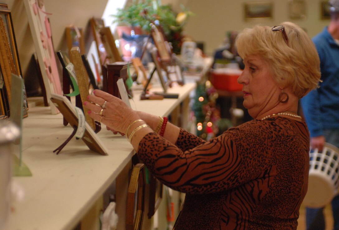 Barbara Schwind, Langley Thrift Shop manager, adjusts a picture frame at the Langley Thrift Shop Nov. 16, 2012, at Langley Air Force Base, Va. With a large variety of items, the shop makes an ideal place for a first-time renter or home owner. (U.S. Air Force photo by Airman 1st Class R. Alex Durbin/Released)