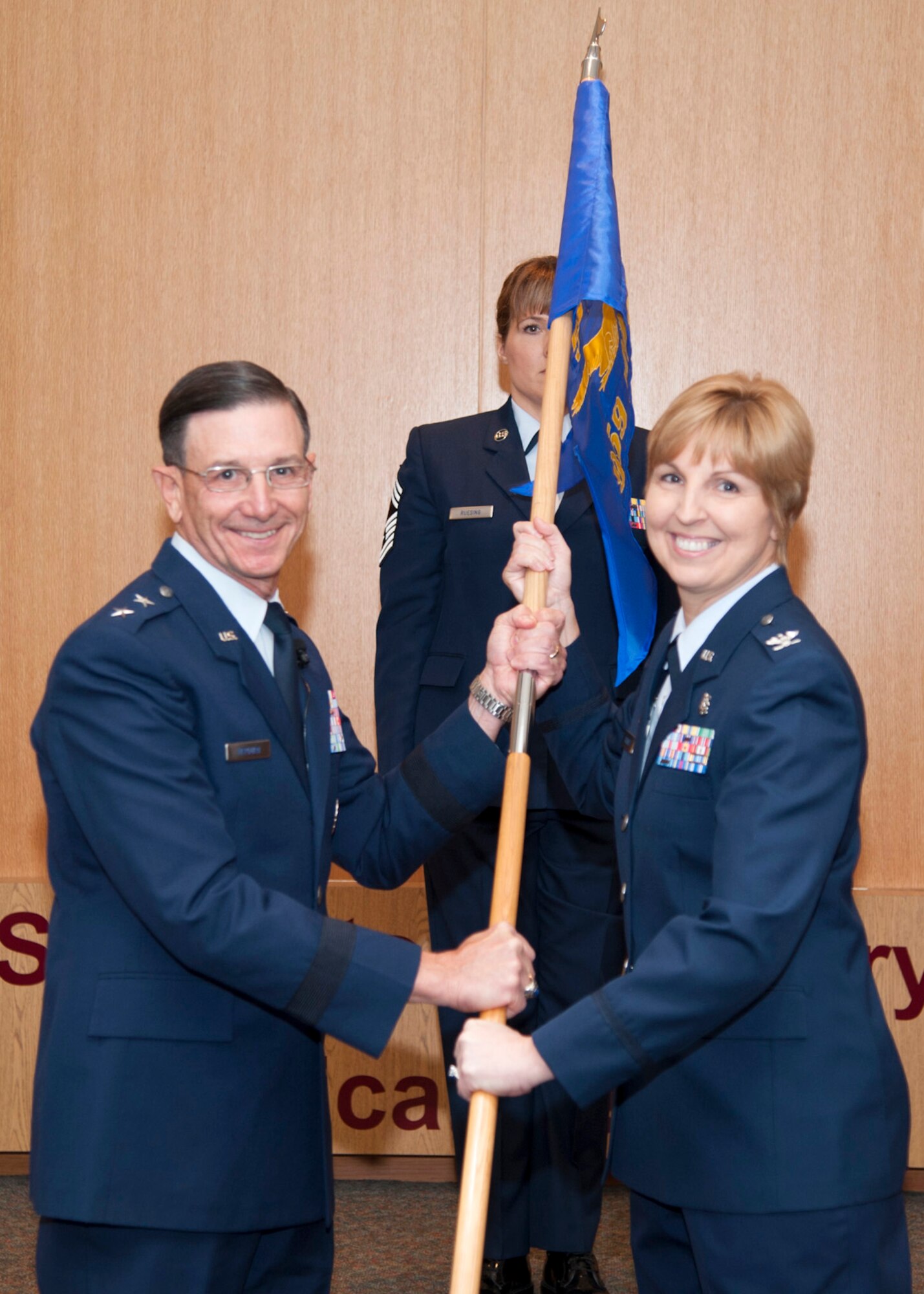 U.S. Air Force Maj. Gen. Byron Hepburn (left) passes the unit guideon to Col. Lisa Schmidt as she accepts command of the 959th Medical Group during the unit's activation ceremony Nov. 16 at San Antonio Military Medical Center, Joint Base San Antonio-Fort Sam Houston, Texas. The move realigns medical services and administrative staff to provide better health care in the San Antonio Military Health System. Hepburn is commander of the 59th MDW and director of the San Antonio Military Health System. (U.S. Air Force photo/Staff Sgt. Kevin Iinuma)