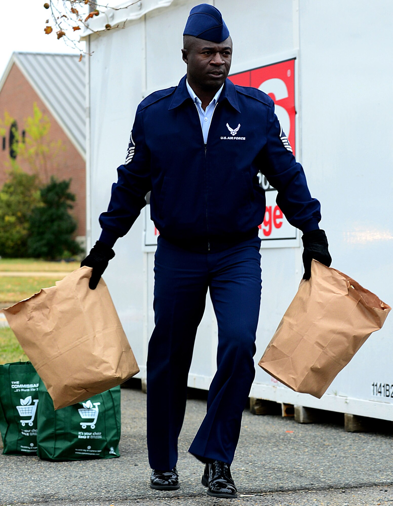 U.S. Air Force Master Sgt. Kenry Peart, 633rd Comptroller Squadron first sergeant, carries bags filled with groceries to a nearby car for distribution at Langley Air Force Base, Va., Nov. 19, 2012.  First Sergeants coordinate with supervisors to identify Airmen who would benefit most from the baskets that are donated through the Operation Warmheart program.  (U.S. Air Force photo by Airman 1st Class Kayla Newman/Released)