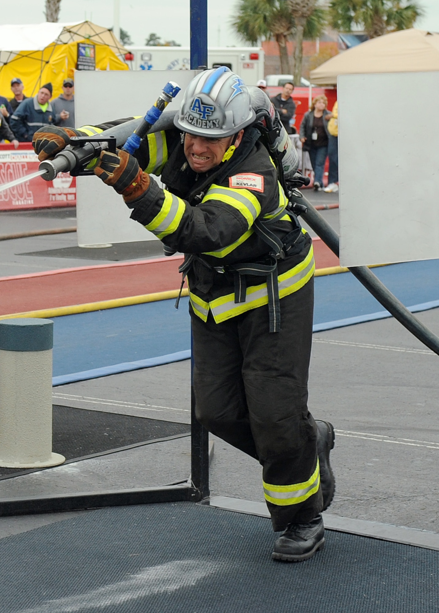 Air Force Academy firefighter Ron Prettyman hits a target with a stream from a firehose, during the over-40 relay team competition at the World Firefighter Combat Challenge XXI Nov. 17, 2012. The Air Force Academy's over-40 team won the 2012 championship, which it won previously in 2009. (U.S. Air Force photo/John Van Winkle)
