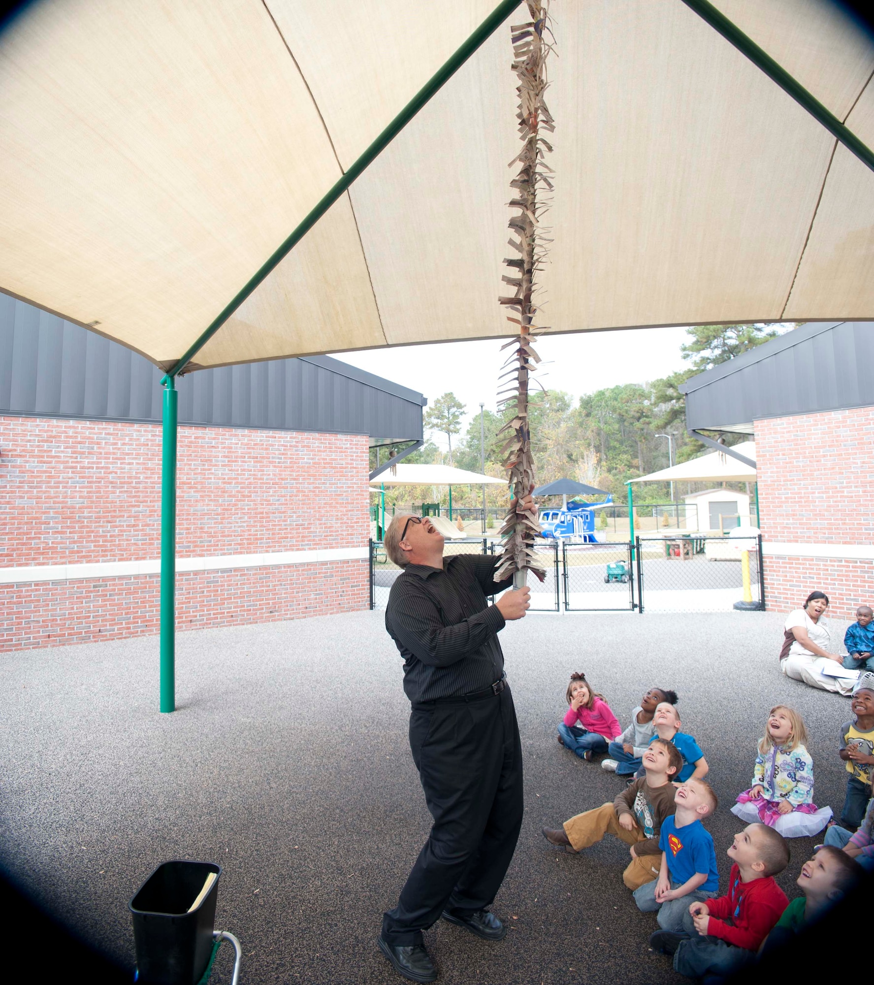 Greg Allen, The Magic of Recycling presenter, performs a newspaper magic trick for children at the Child Development Center, Moody Air Force Base, Ga., Nov. 13, 2011. The trick informed children about how many trees are cut down to make paper and how recycling helps save trees. (U.S. Air Force photo by Airman 1st Class Paul Francis/Released)
