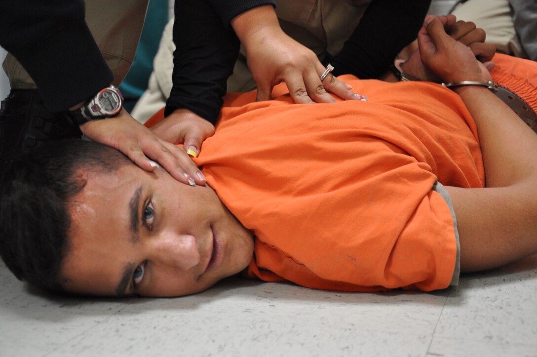 2nd Lt. Cody Gutierrez, from the Laughlin Air Force Base, Texas, is forced to the ground and handcuffed by Val Verde County prison staff, during a mock prison riot Nov. 14, 2012. The live exercise was designed to give the guards and medical staff hands-on training as if a real prison incident had occurred. (U.S. Air Force Photo/2nd Lt. David Tart) 