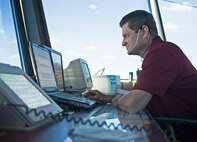 Jason Coody, 12th Operations Support Squadron air traffic controller, monitors radio traffic through his headset at the east tower Aug. 14 at Joint Base San Antonio-Randolph. (U.S. Air Force photo by Benjamin Faske)