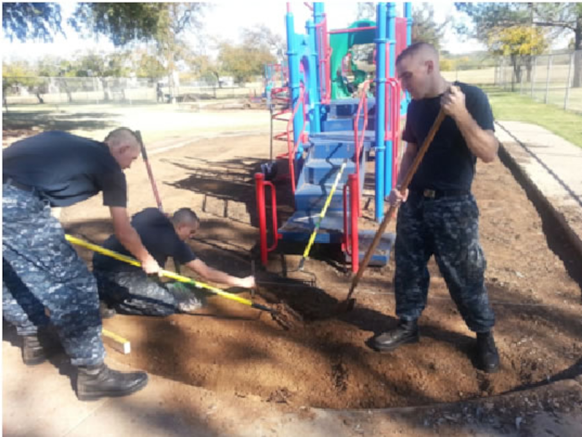 Navy students from the 366th Training Squadron CSFE Det at Sheppard Air Force Base measure 6-inch depth to prepare for digging and tilling the soil Nov. 7 in Wichita Falls, Texas.  The Seabee students helped install new playground matting for the Children's Aid Society in a community support project. (U.S. Air Force courtesy photo/PO1 Jennifer Mosby)