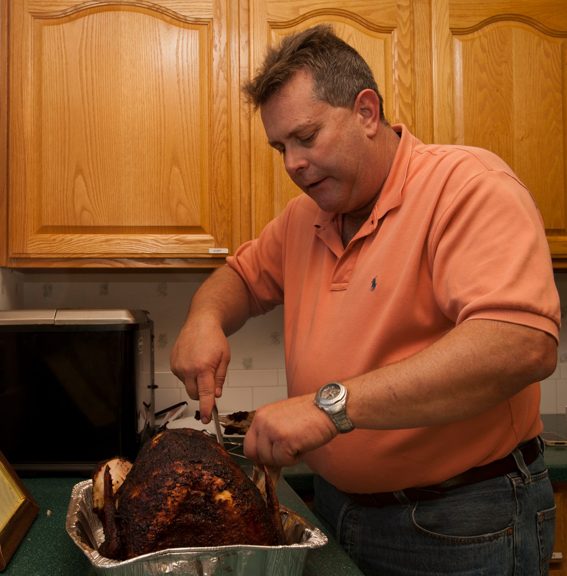 Steve Yavornitzki, 22nd Air Refueling Wing Protocol and Planning combat operations officer, carves a hand-prepped fried turkey he made for the director of staff Thanksgiving lunch Nov. 9, 2012, McConnell Air Force Base, Kan. Yavornitzki is known for the fried turkeys he has been making for more than 20 years. (U.S. Air Force/Airman 1st Class Victor J. Caputo)