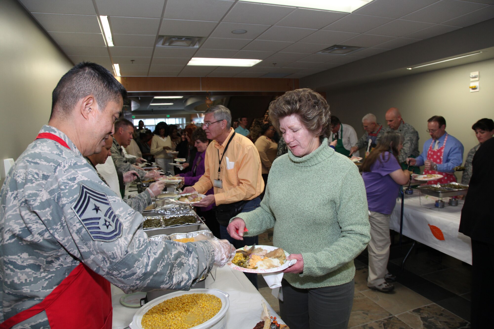Chief Master Sgt. Brian Wong, Air Reserve Personnel Center command chief, prepares to serve Marjie Kaufman and Michael Aerne, during the annual ARPC Thanksgiving luncheon held Nov. 14, 2012, at the ARPC headquarters on Buckley Air Force Base, Colo. (U.S. Air Force photo/Quinn Jacobson)