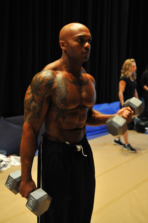U.S. Air Force Master Sgt. LaJuan Fuller, 366th Civil Engineer Squadron first sergeant, lifts some small weights to warm up his muscles before his body building competition April 28, 2012, in Boise, Idaho. Fuller has participated in more than 18 competitions. (U.S. Air Force photo/Airman 1st Class Heather Hayward)