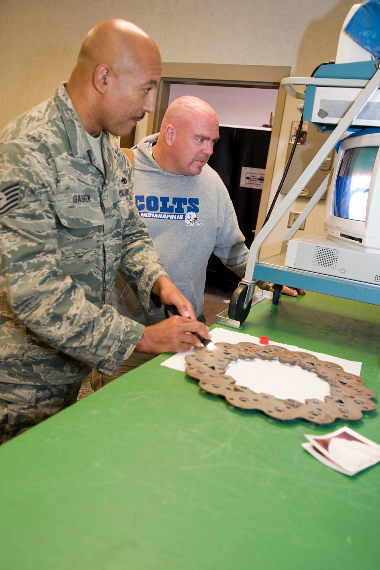 Tech. Sgt. Jimmie Gaskew, 434th Maintenance Squadron nondestructive inspection journeyman, uses an imaging device to magnify the surface of an aircraft part as he looks for cracks while Leilan McNally, 434th Maintenance Group honorary commander watches. Grissom's honorary commanders visited the base recently to learn about the 434th MXG. (U.S. Air Force photo/ Tech. Sgt. Mark Orders-Woempner)

