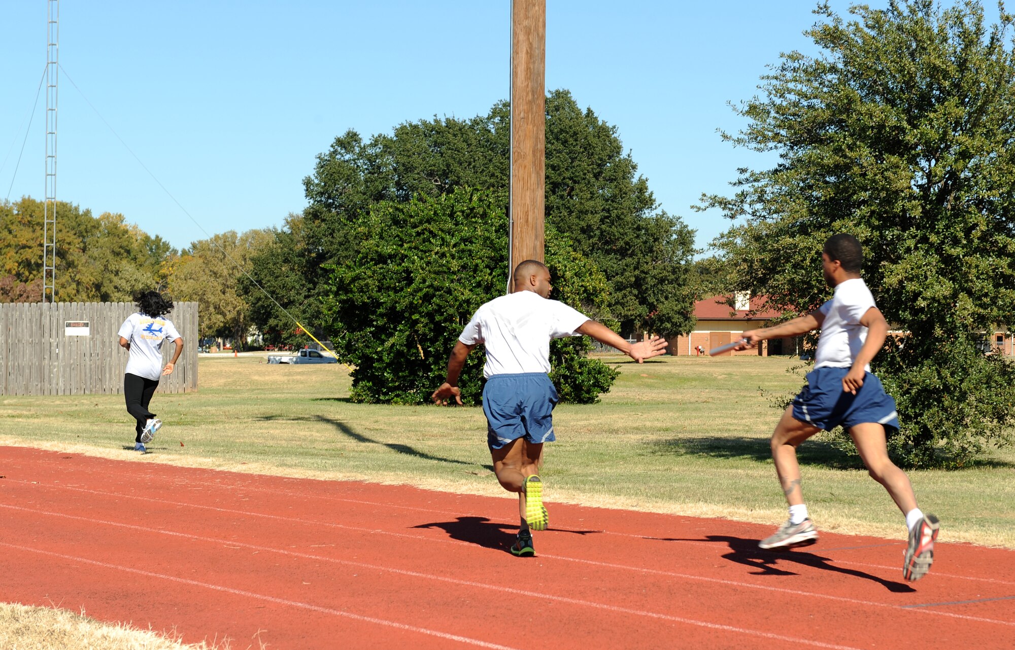 A Barksdale Airman passes off a baton during the 4x100 relay race and part of the 2012 Sports Day on Barksdale Air Force Base, La., Nov. 16. Sports Day consisted of various team events including dodgeball, basketball, soccer, tug-of-war, volleyball, a homerun derby, flag football and racquetball. This day was designed to improve teamwork, and help increase the awareness of fitness, sports programs and boost morale. (U.S. Air Force photo/Airman 1st Class Benjamin Gonsier)(RELEASED)

