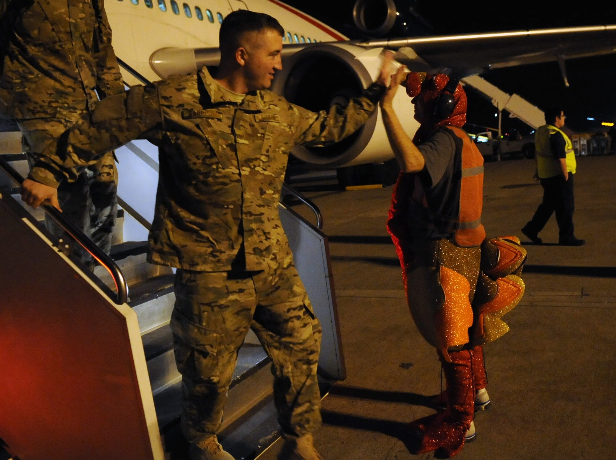 Tech. Sgt. Michael Nix, 728th Air Mobility Squadron assistant section chief, greets transient deployers dressed as a turkey to bring some Thanksgiving cheer as they stop at Incirlik Air Base, Turkey Nov. 16, 2012. The jet stopped at Incirlik to change out the air crew, refuel and dropp off new arrivals before continuing on to the deployment location. (U.S. Air Force photo by Senior Airman Daniel Phelps/Released)