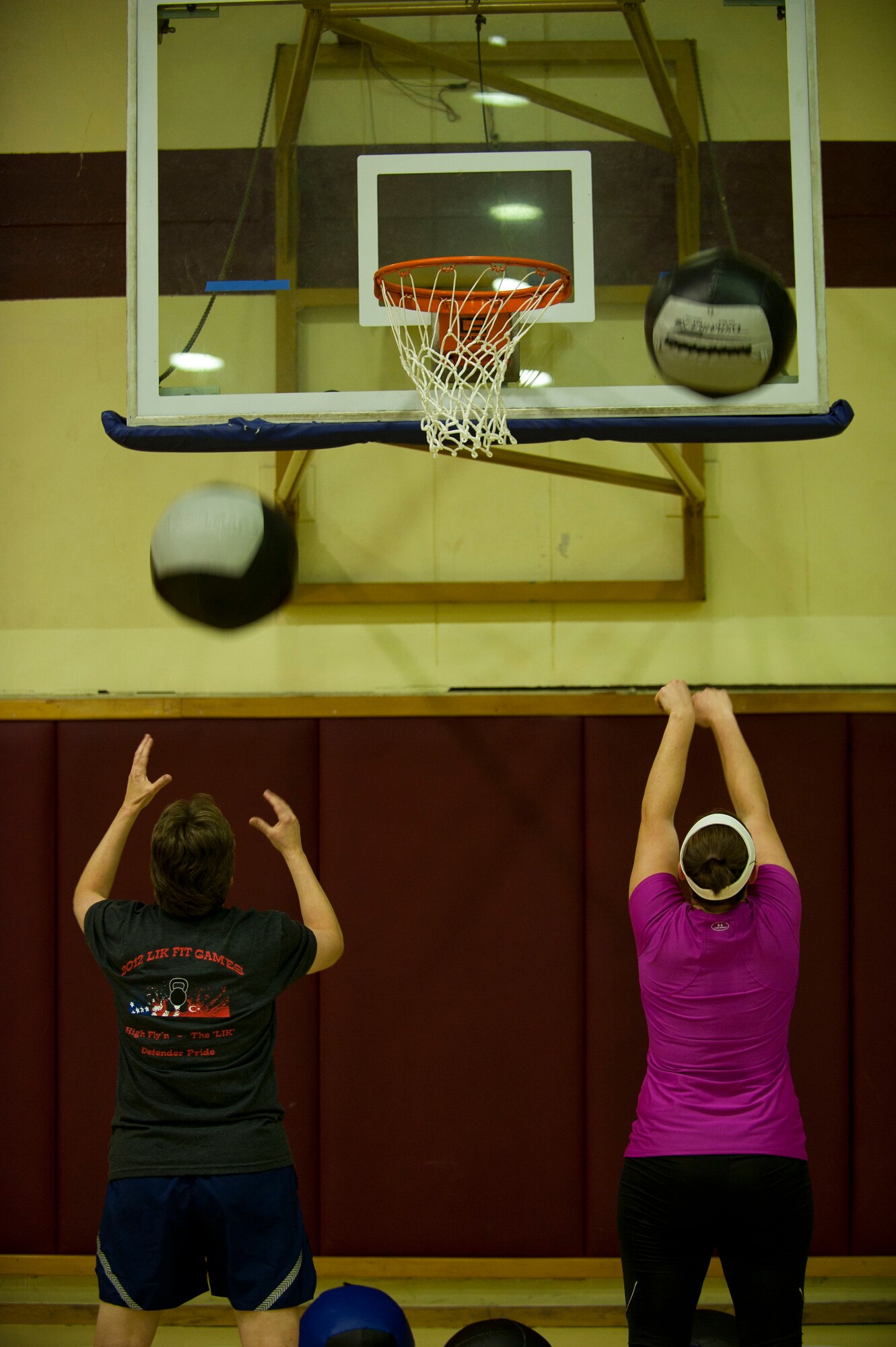 Nancy Judge, left, 39th Air Base Wing command chief, and Kristi MacDonald, Armed Forces Network Incirlik, take part in the wallball shots portion of the Lik Fit Challenge Nov. 14, 2012, at Incirlik Air Base, Turkey. Other exercises at the event consisted of push presses, sumo deadlift high pulls, plyo-box jumps and Rowing. (U.S. Air Force photo by Senior Airman Clayton Lenhardt/Released)