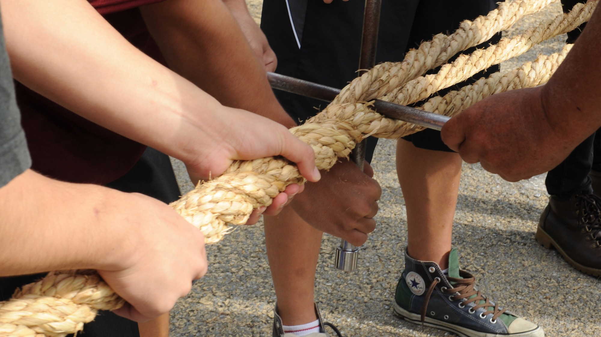 U.S. service members and members of the local Okinawan community twist ropes together in preparation of the International Tug-of-War in Okinawa City, Japan, Nov. 18, 2012. Five ropes were twisted together then joined with two other ropes to create the final gigantic rope for the International Tug-of-War. (U.S. Air Force photo/Airman 1st Class Malia Jenkins)

 