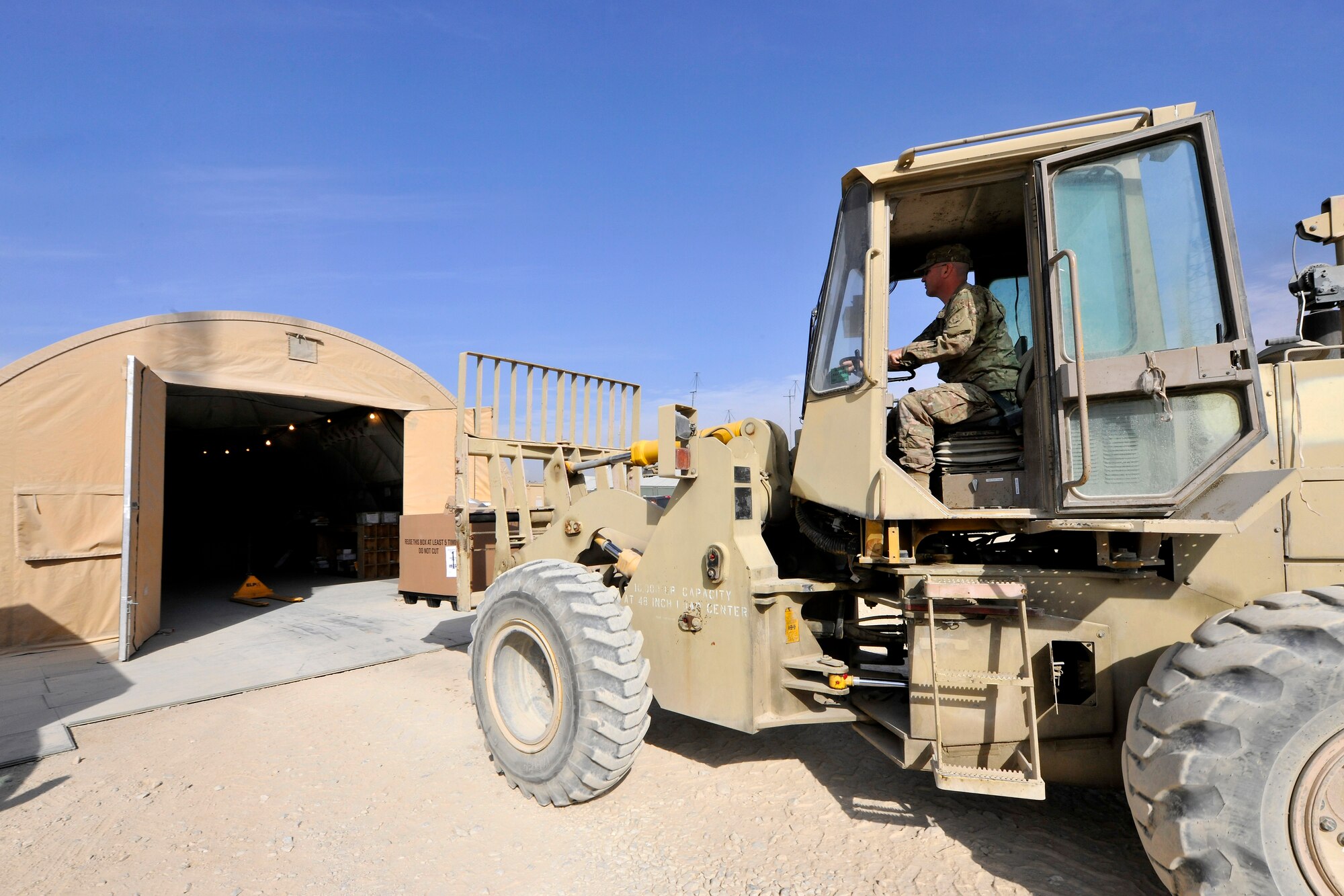 Tech. Sgt. Nathan Talavera, a member of the 455th Expeditionary Knowledge Operations Management office, carefully lowers a container of mail onto the receiving area of the postal annex at Bagram Airfield, Afghanistan, Nov. 15, 2012.  BAF Airmen receive an average of 18 containers of mail per day and more than 35 containers during the holiday season. (U.S. Air Force photo/Senior Airman Chris Willis)