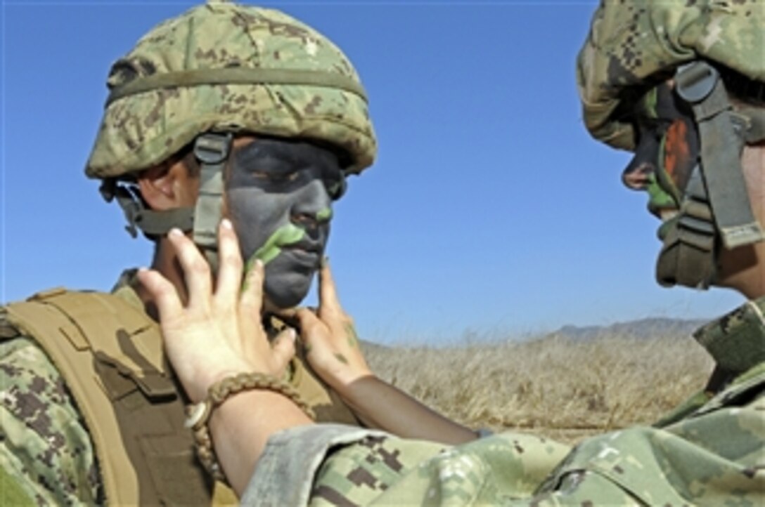 Seaman Recruit Michael Torres has his face painted to help camouflage him during a field training exercise at Camp Pendleton, Calif., on Nov 6, 2012.  Torres is assigned to Amphibious Construction Battalion 1.  The battalion provides logistical over-the-shore support for amphibious forces and the maritime prepositioned force operations, including ship-to-shore transportation of combat cargo, bulk fuel and water and tactical camp operations.  